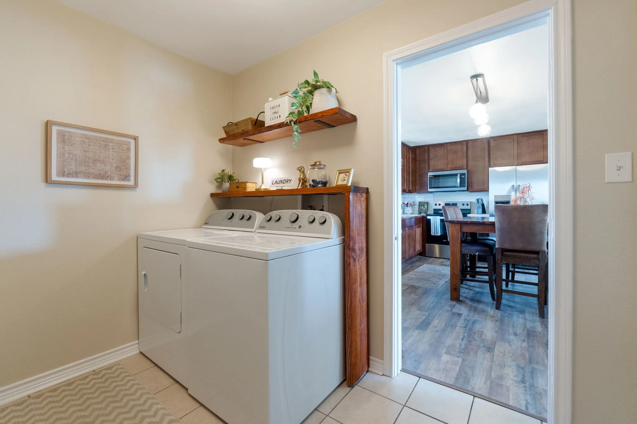 Laundry area with light tile patterned floors and washer and clothes dryer