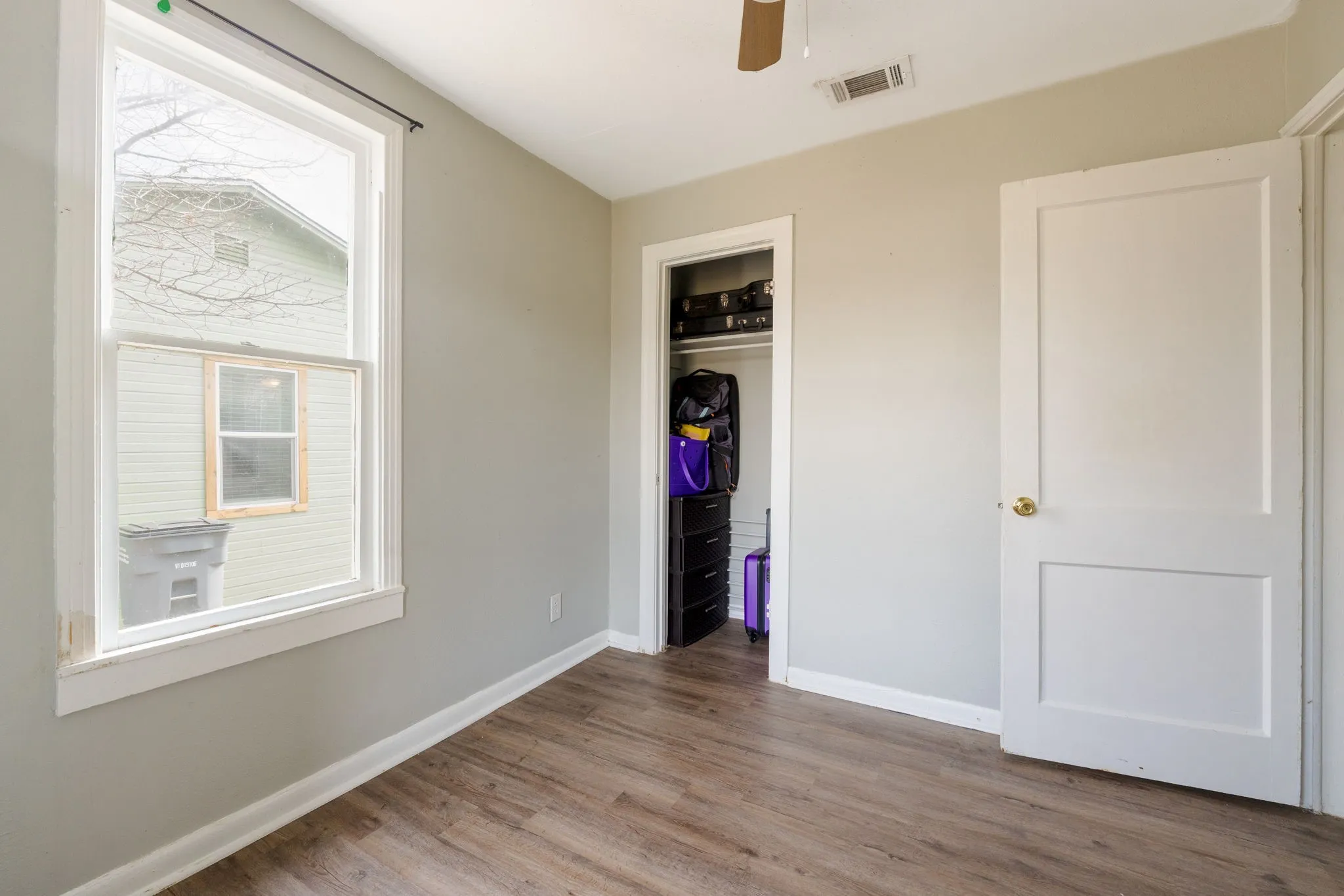 Unfurnished bedroom featuring light wood-style floors, a closet, and ceiling fan