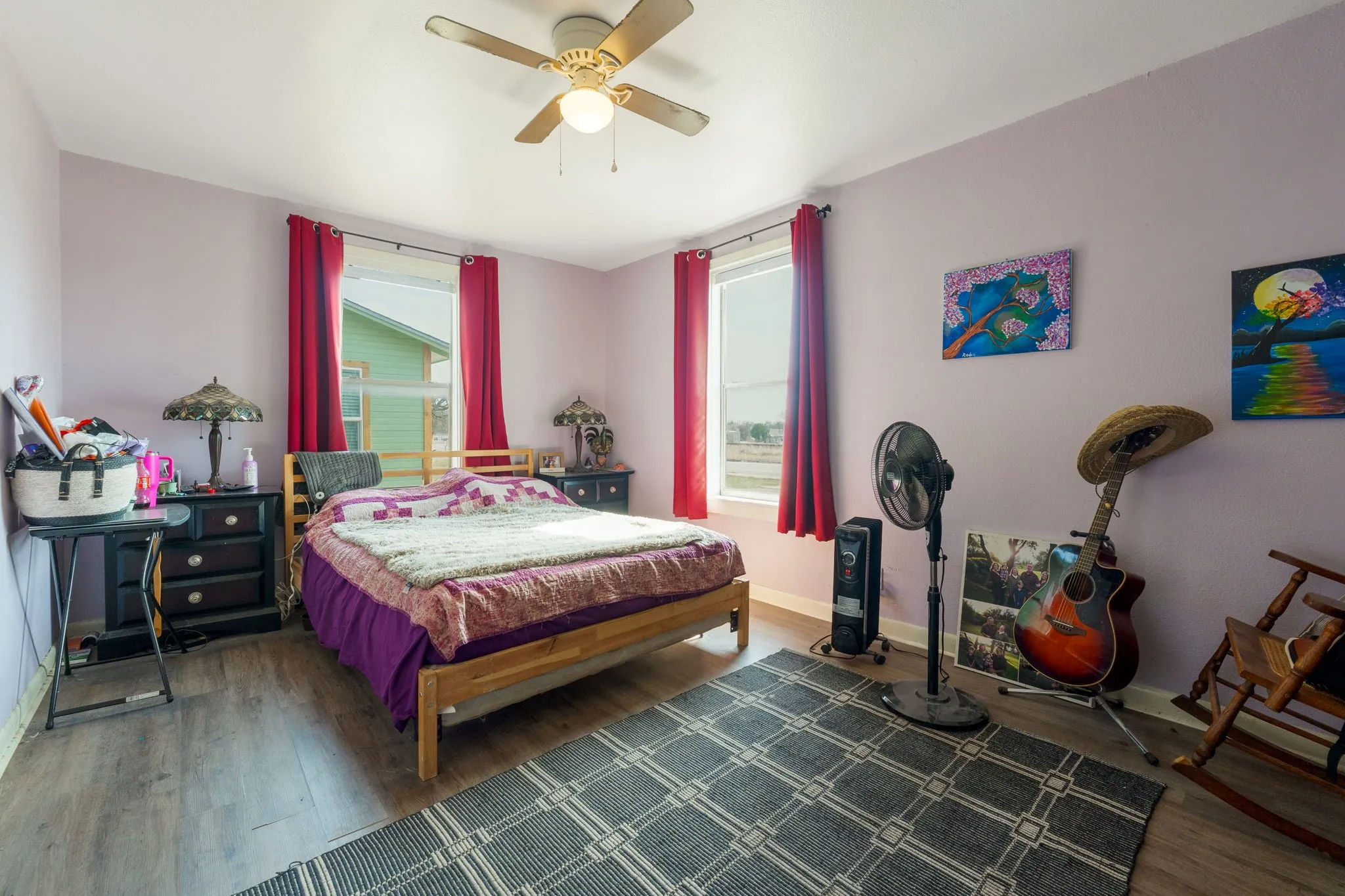 Bedroom featuring wood finished floors, ceiling fan, and multiple windows