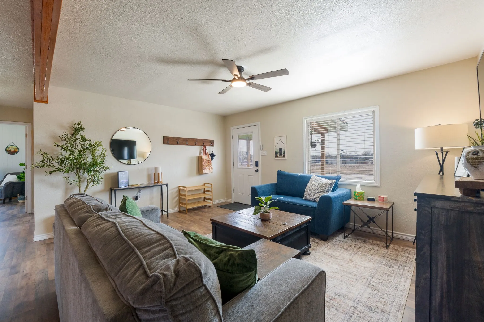 Living area with wood finished floors, a ceiling fan, and a textured ceiling