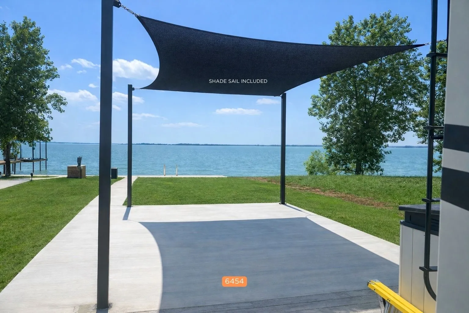 Included shade sail creates a comfortable waterfront concrete pad setting.Shade sail covered patio space overlooking the waterfront near Dallas.