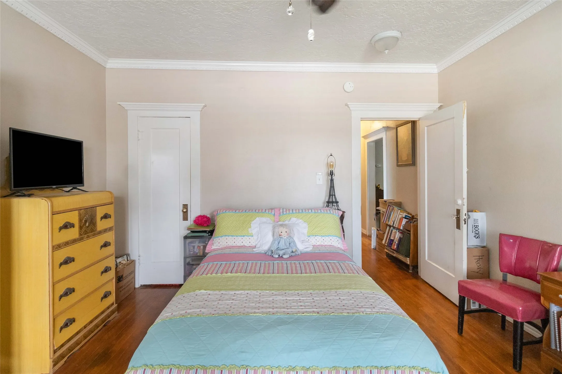 Bedroom with dark wood-style flooring, a textured ceiling, and ornamental molding