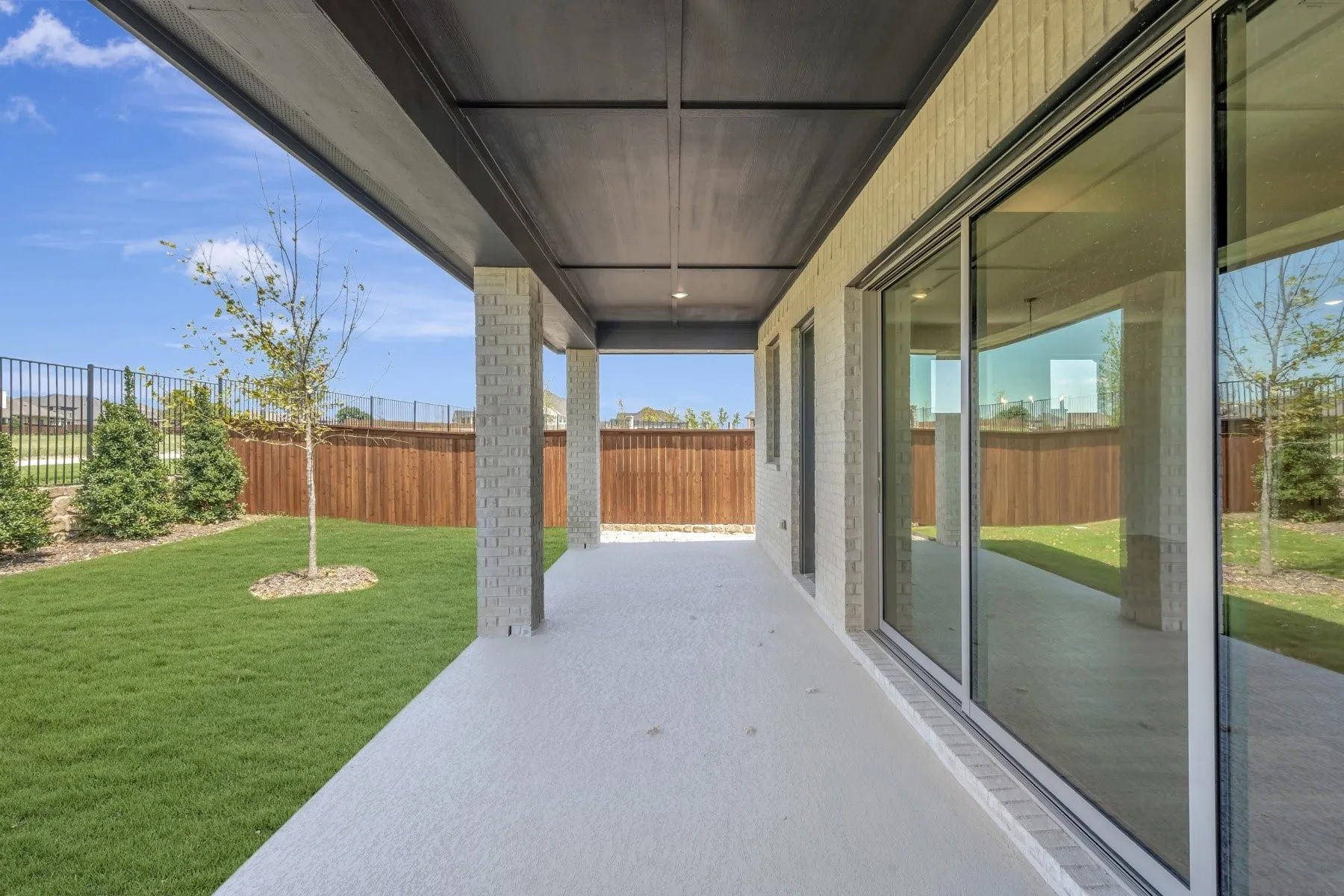 Covered outdoor patio with a concrete surface and brick columns