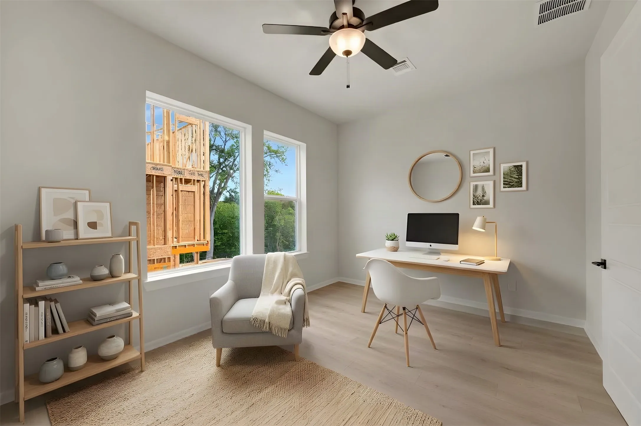Light-filled interior space featuring two large windows, wood-finish flooring, a ceiling fan with integrated lighting, and a white paneled door with matte black hardware