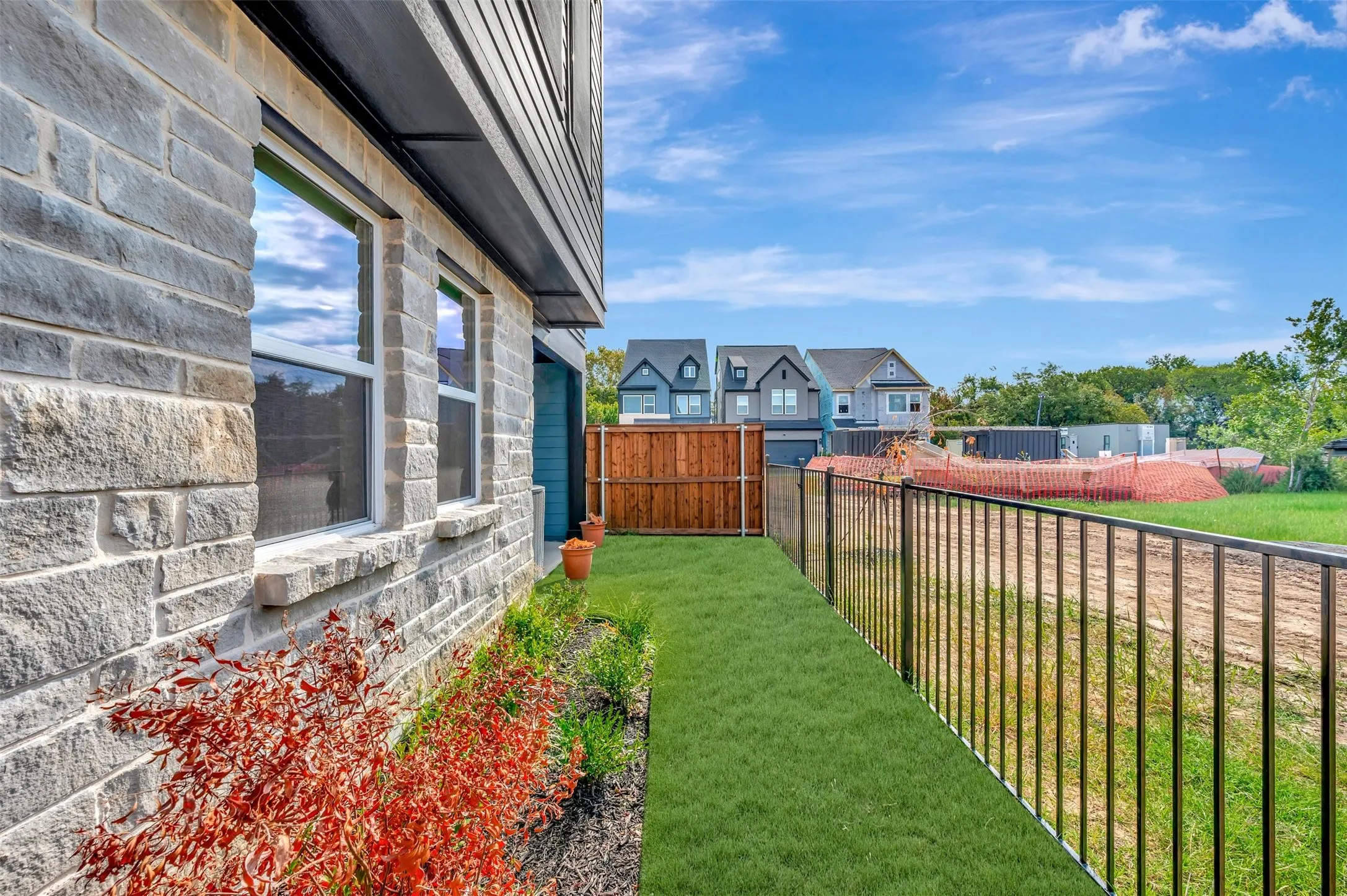 Stone exterior with dark siding accents, double pane windows, and a manicured lawn