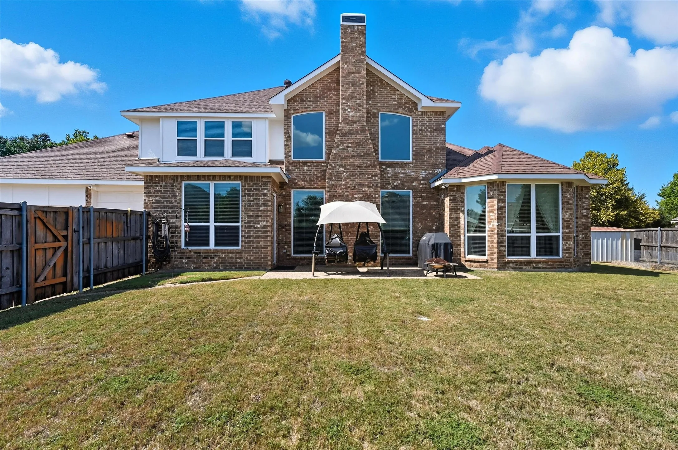 Spacious backyard featuring an oversized patio perfect for outdoor entertaining, along with a storage shed for added convenience and functionality.