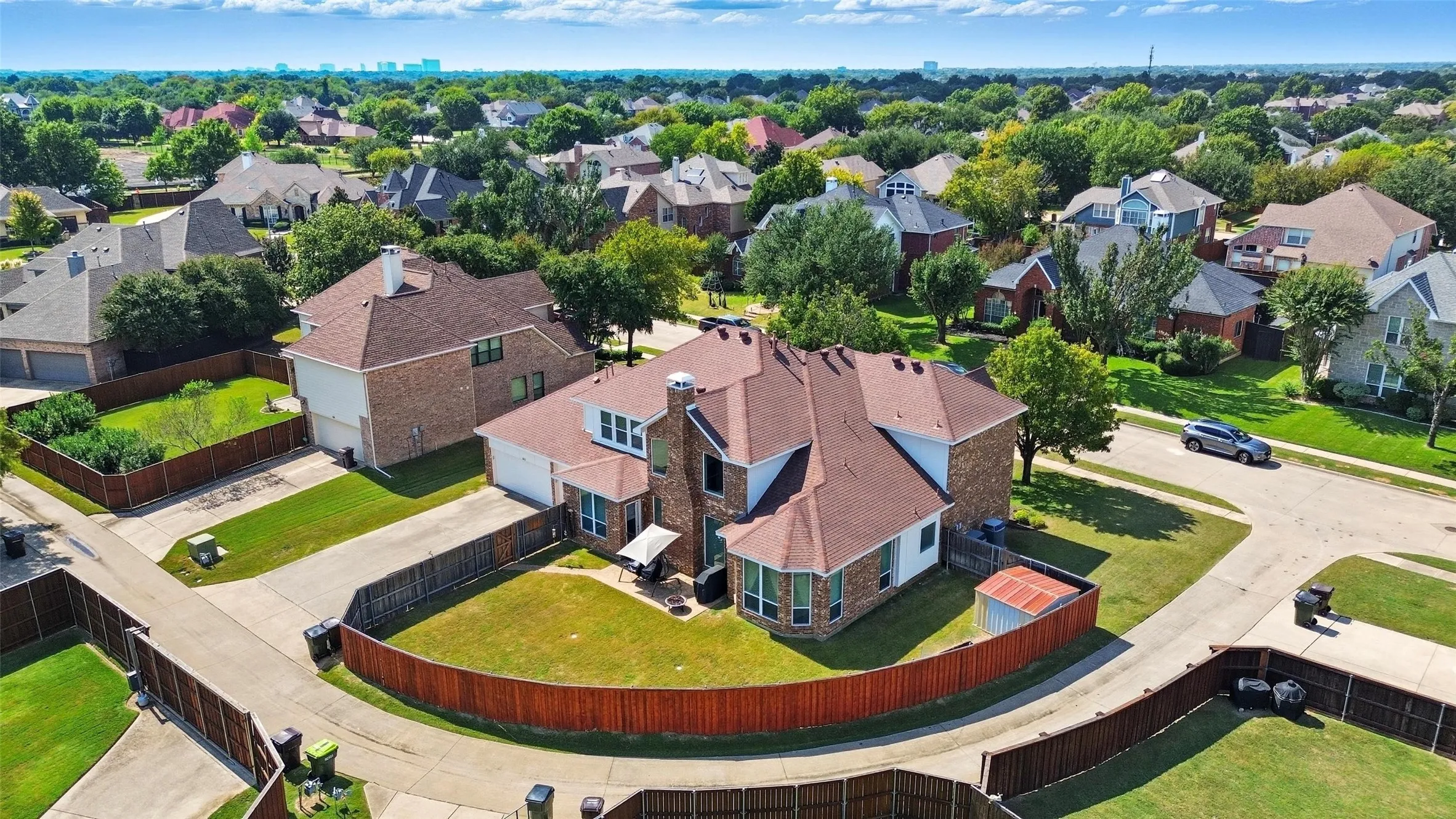Aerial view showcasing the home's spacious backyard, with the Plano skyline and cityscape creating a beautiful backdrop in the distance.
