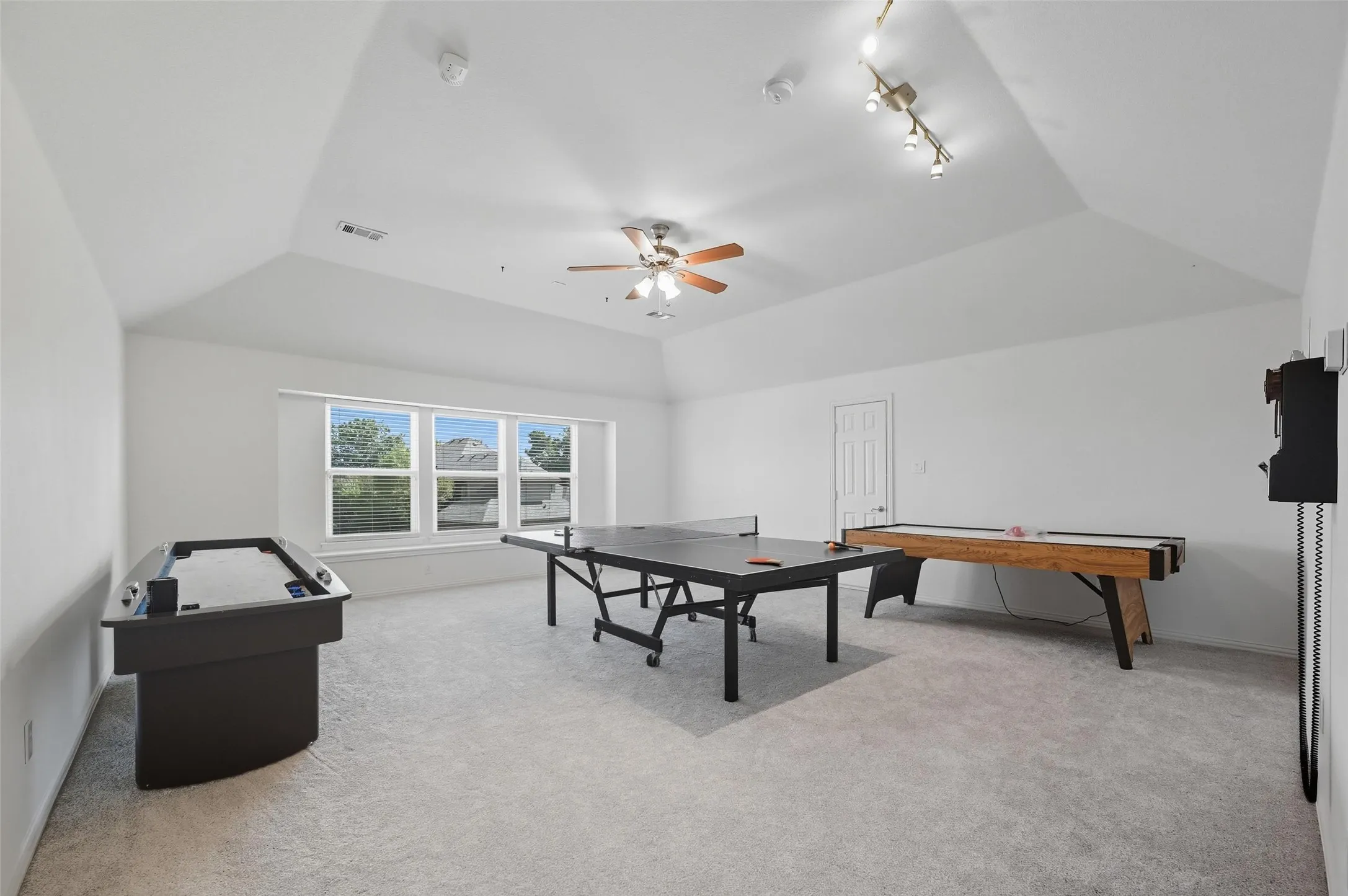Expansive game room spanning the footprint of the 3-car garage below, offering incredible flexibility and direct access to a walk-out attic for convenient storage.