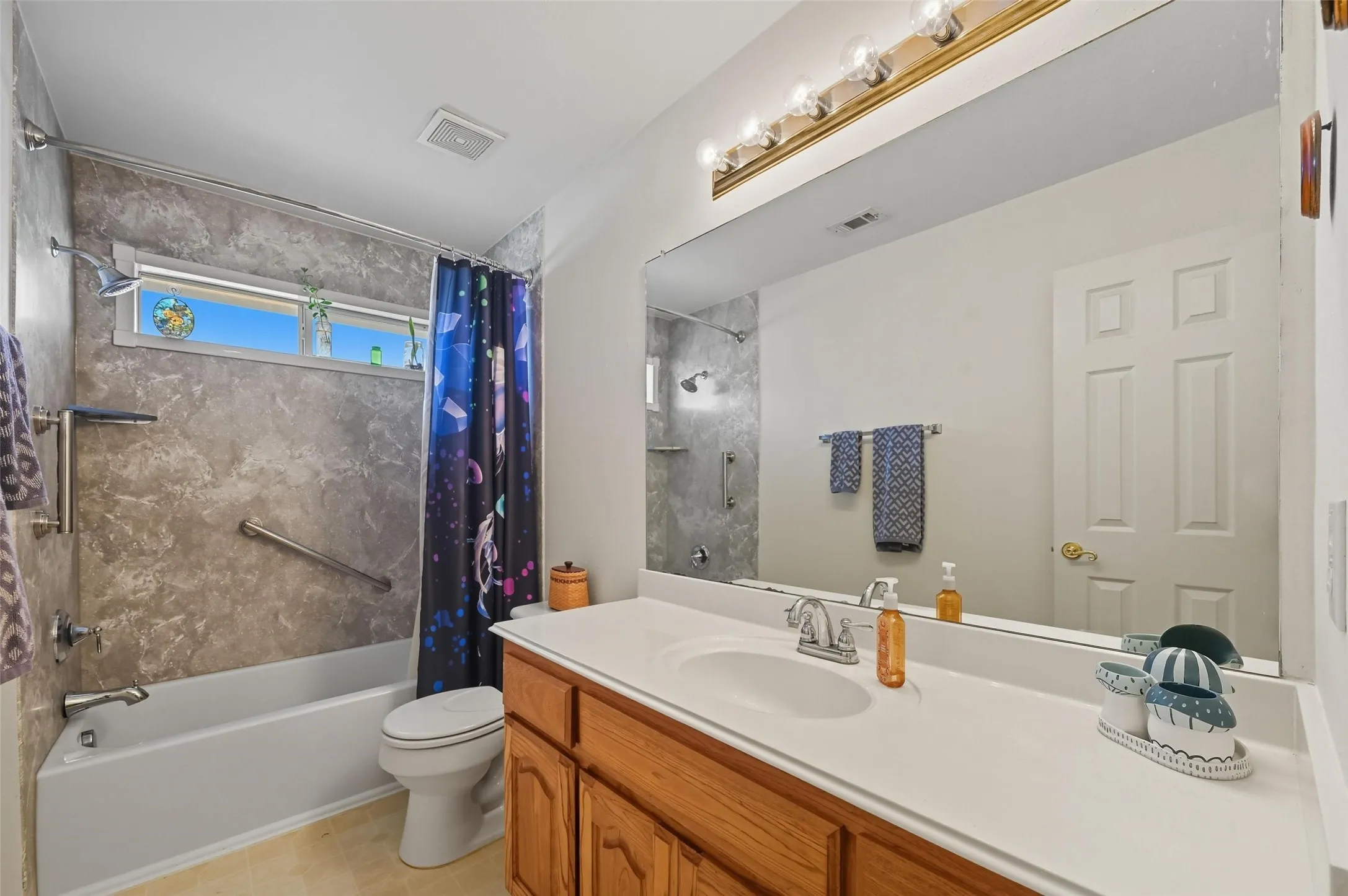 Upstairs bath offers generous countertop space and a tub/shower combination accented by a window that brings in natural light.