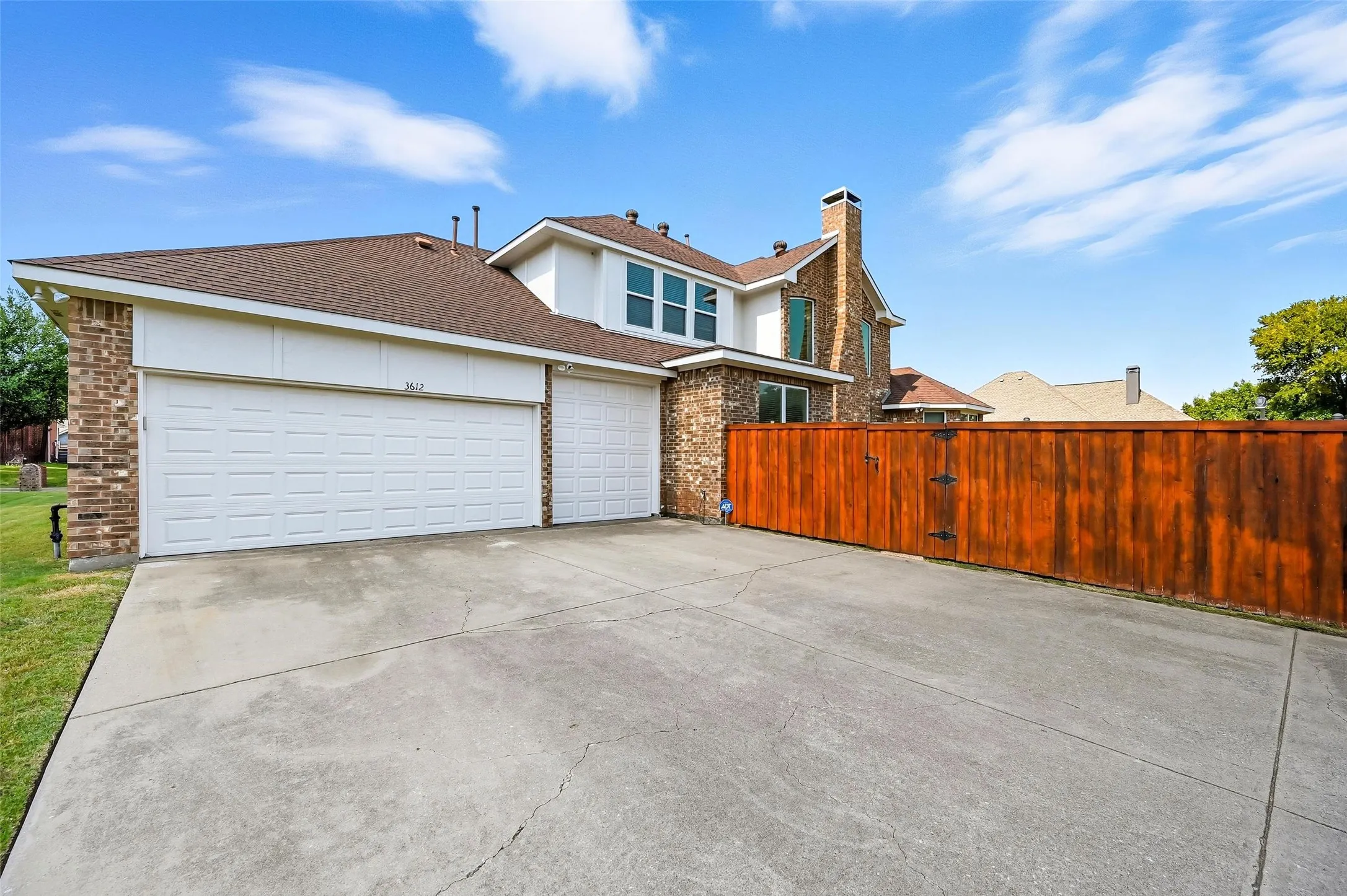 Oversized 3-car garage featuring a raised third bay with room for small RV storage, 220V electrical outlets, and a tandem workshop area—perfect for hobbies, projects, or additional storage.