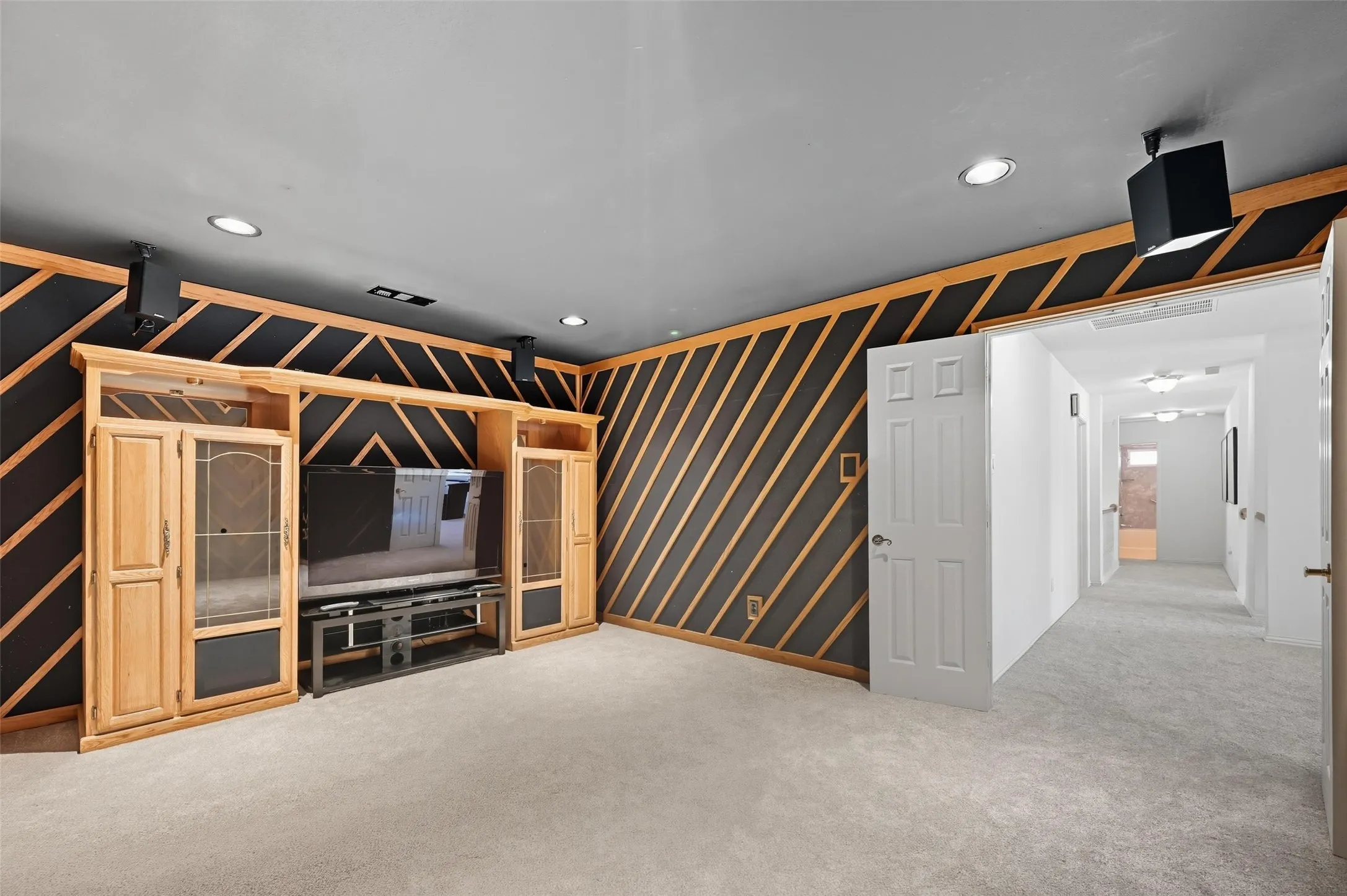 Dedicated media room featuring sound-absorbing wall panels and no windows, creating the ideal environment to enjoy movies, sports, or gaming without disturbing others in the home.