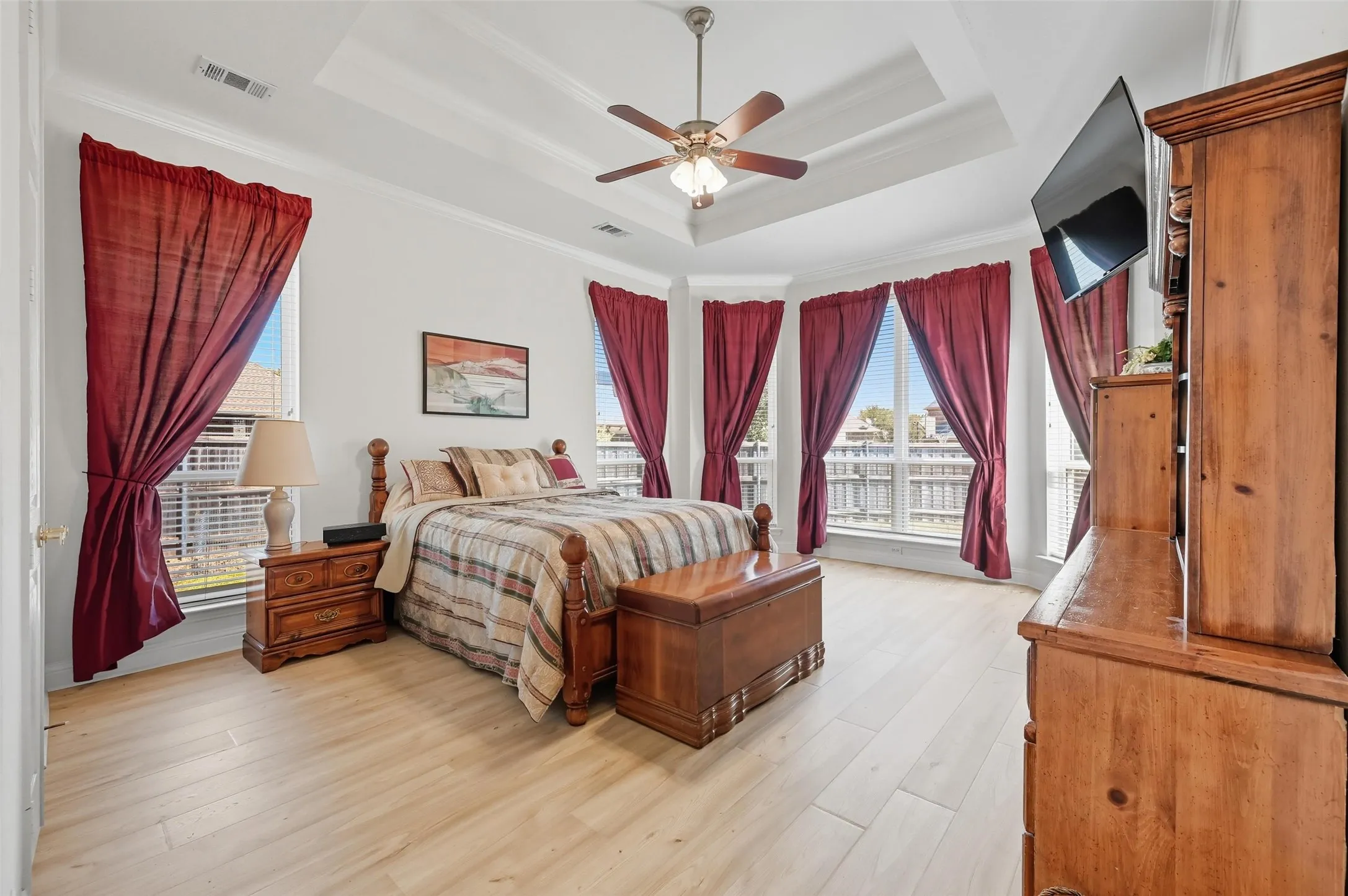 Spacious primary suite featuring a tray ceiling, charming bay window, room for a sitting area, and a private ensuite bath designed for relaxation and comfort.
