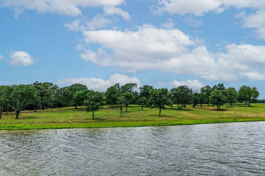 Expansive water frontage with a verdant tree-lined bank