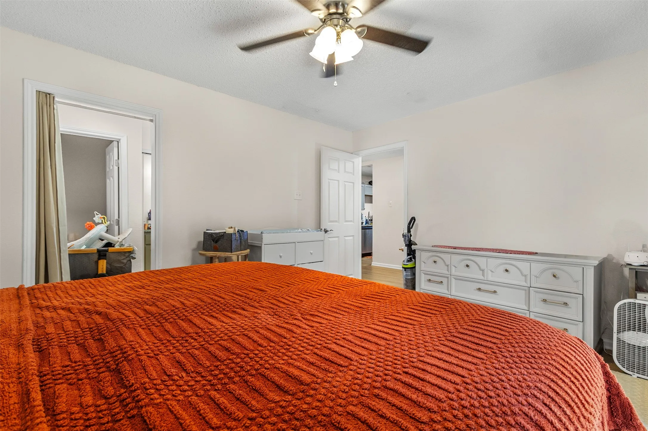 Bedroom with ceiling fan and a textured ceiling