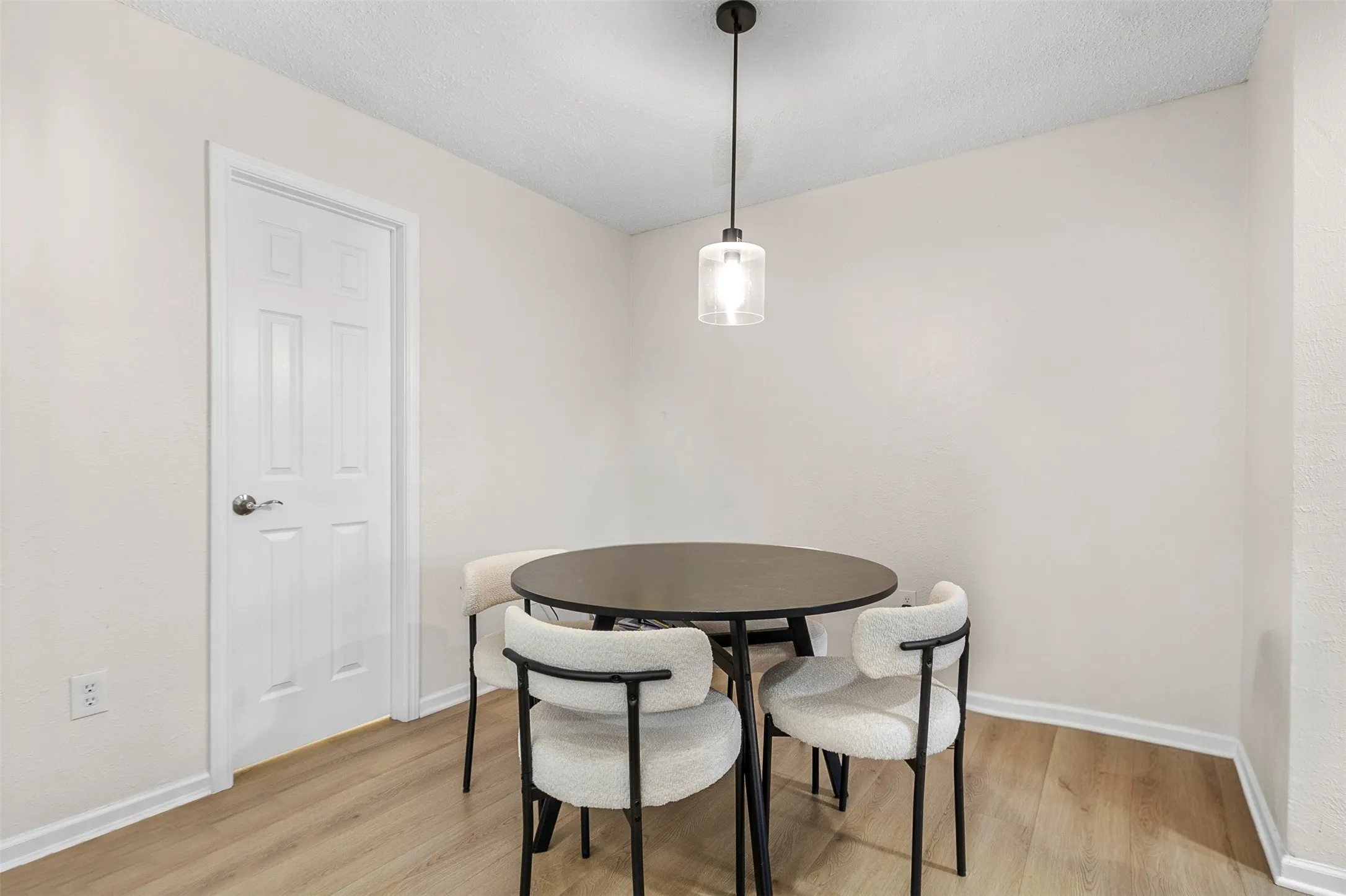 Dining area featuring light wood finished floors and a textured ceiling