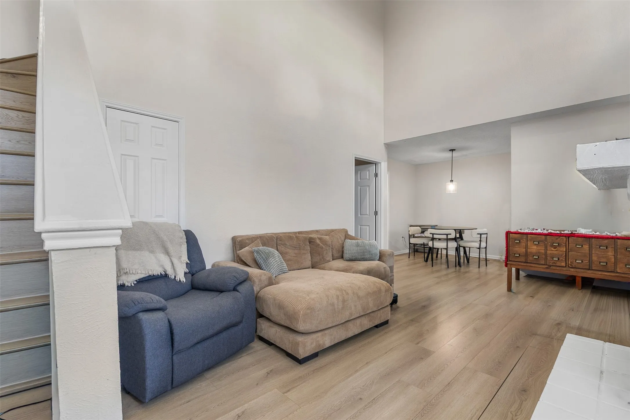 Living room with light wood-style flooring and a high ceiling