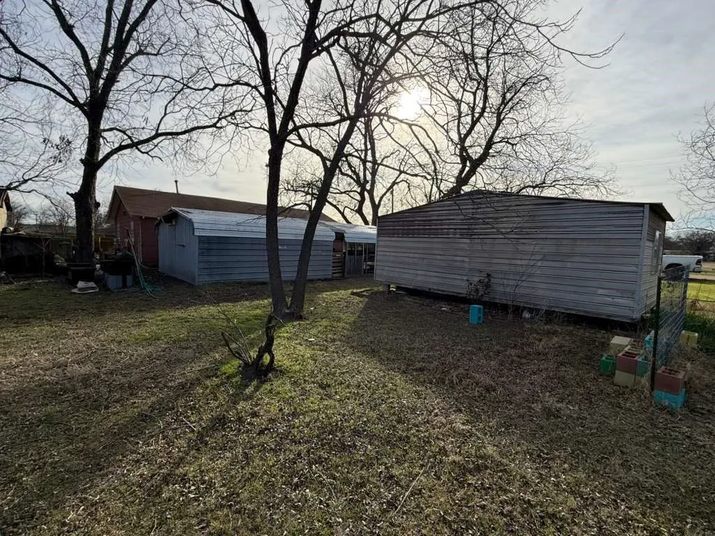 View of green lawn featuring a storage unit