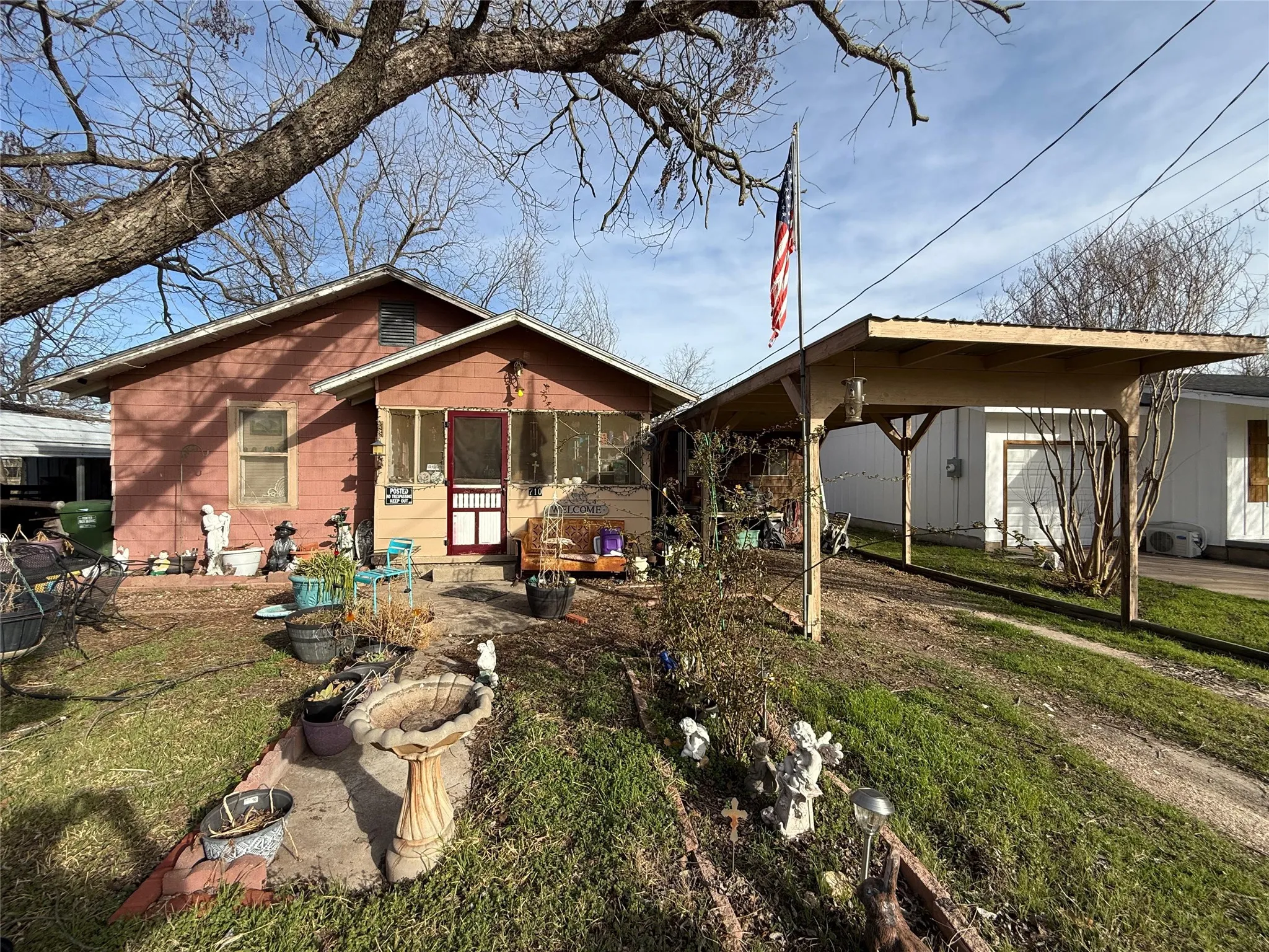 View of front facade with a front yard, a patio, and a carport