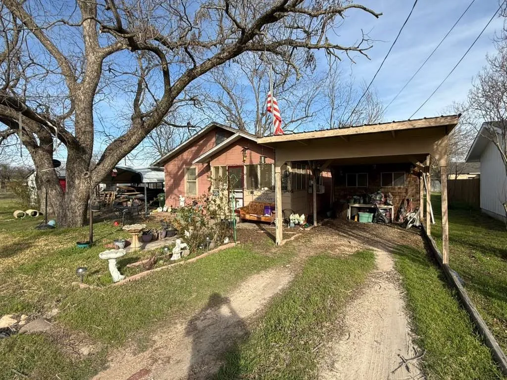 Back of property featuring a lawn and driveway