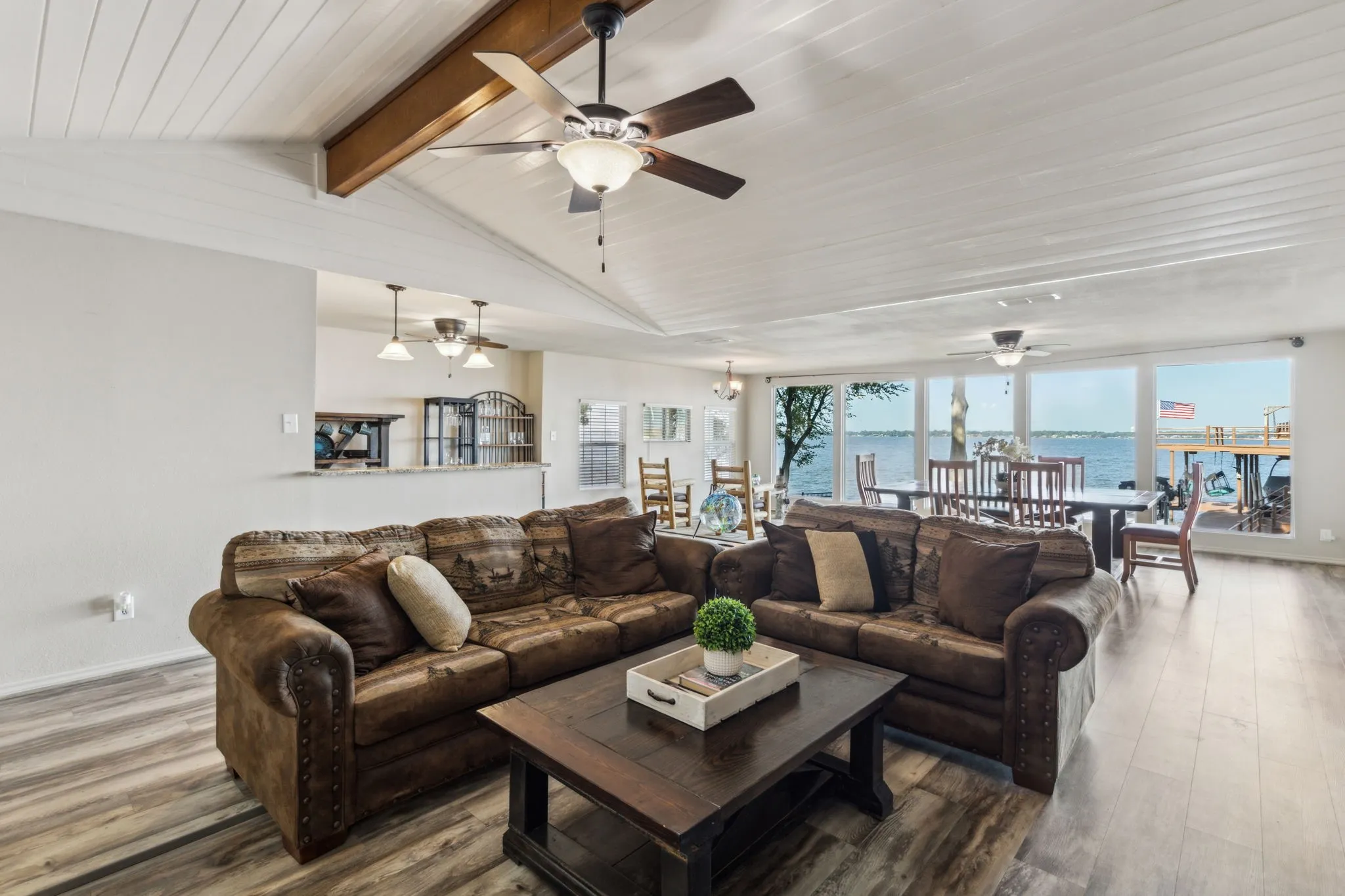 Grand open room with recently replaced flooring, vaulted ceilings and beams.