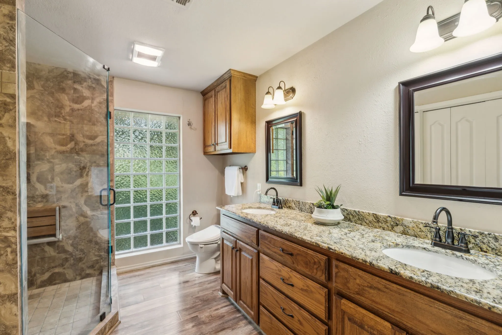 En suite primary bathroom with dual sinks, linen closet and free standing oversized shower.