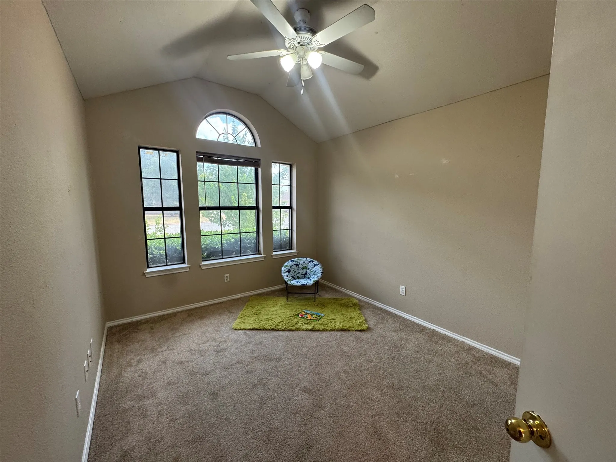 Bedroom with lots of light, ceiling fan, carpet with vaulted ceilings