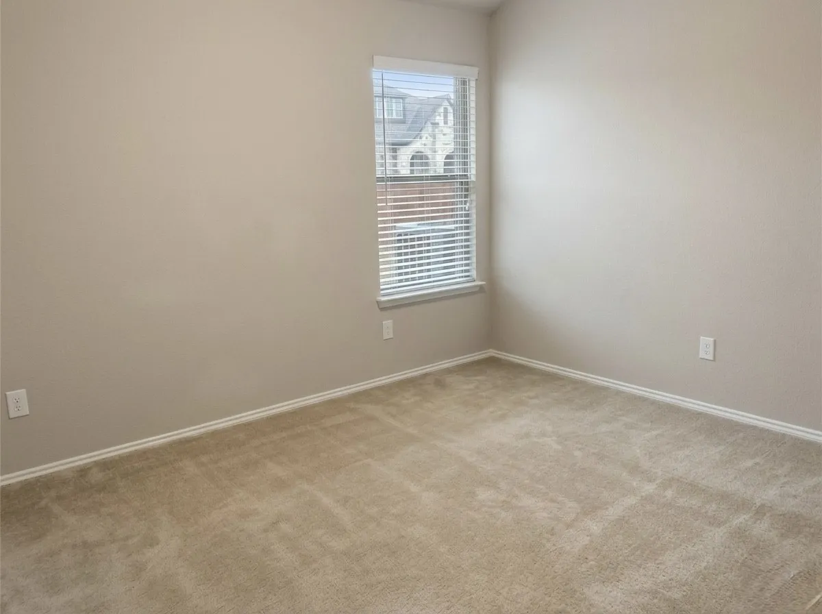 Spare room with light colored carpet and baseboards