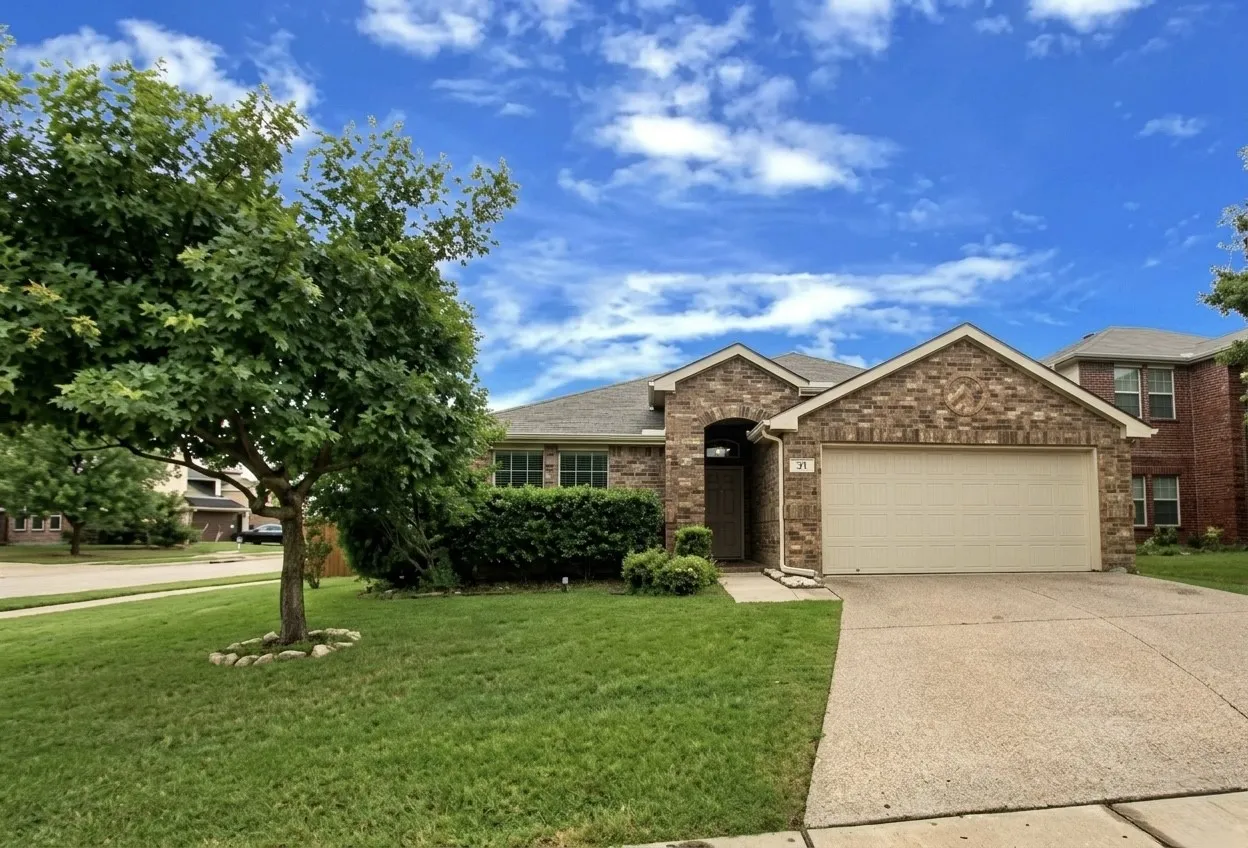 View of front of house featuring a garage, a front yard, brick siding, and driveway