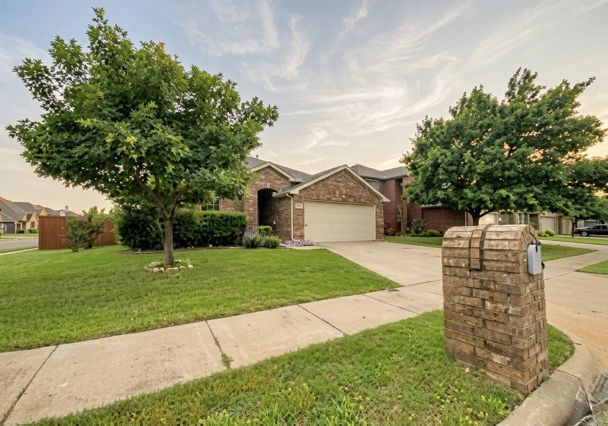 View of front of property featuring a garage, concrete driveway, a front yard, and brick siding