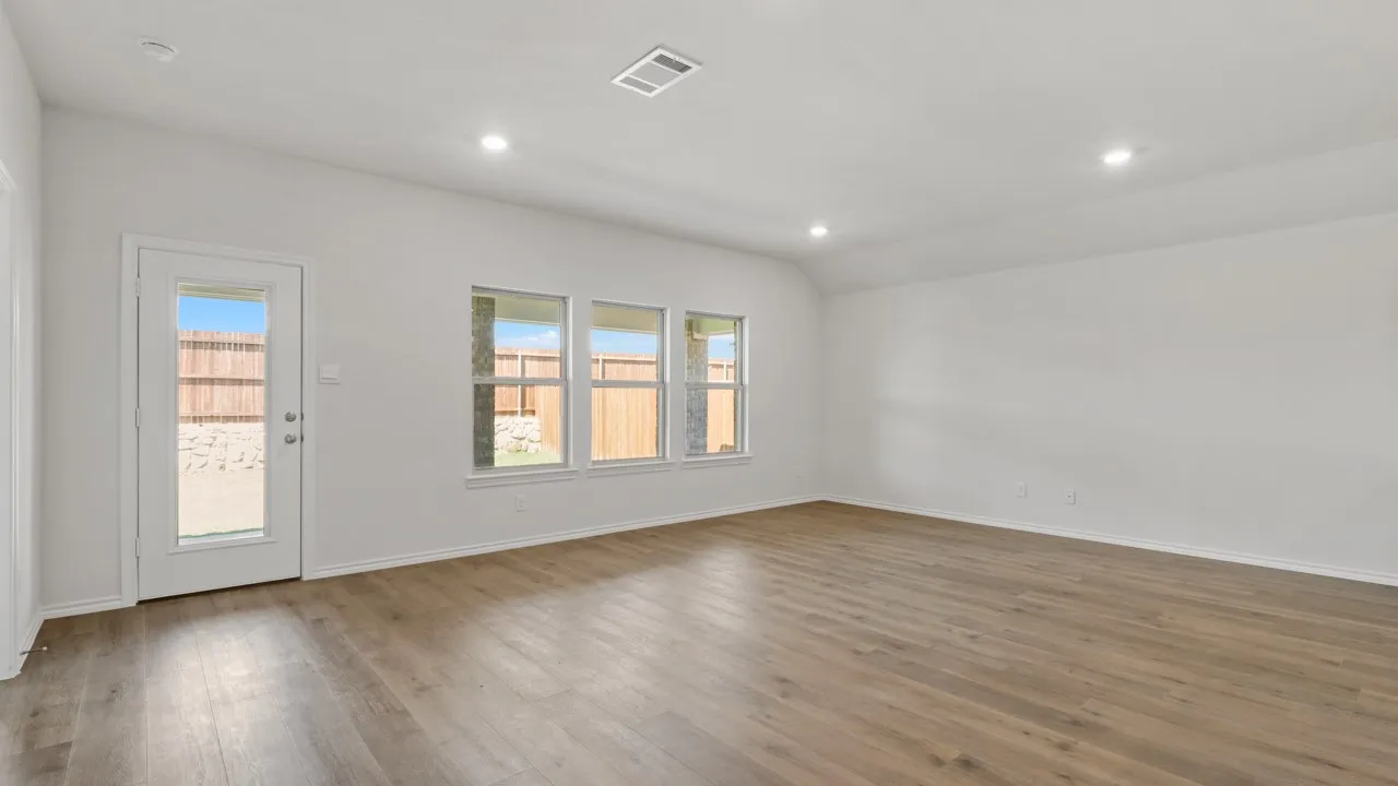 Spacious room featuring wood-finish flooring, recessed lighting, and white walls