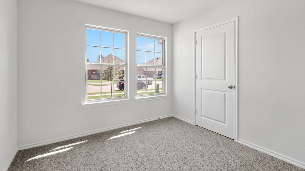 Room with two paneled windows, neutral wall tones, and gray carpeting