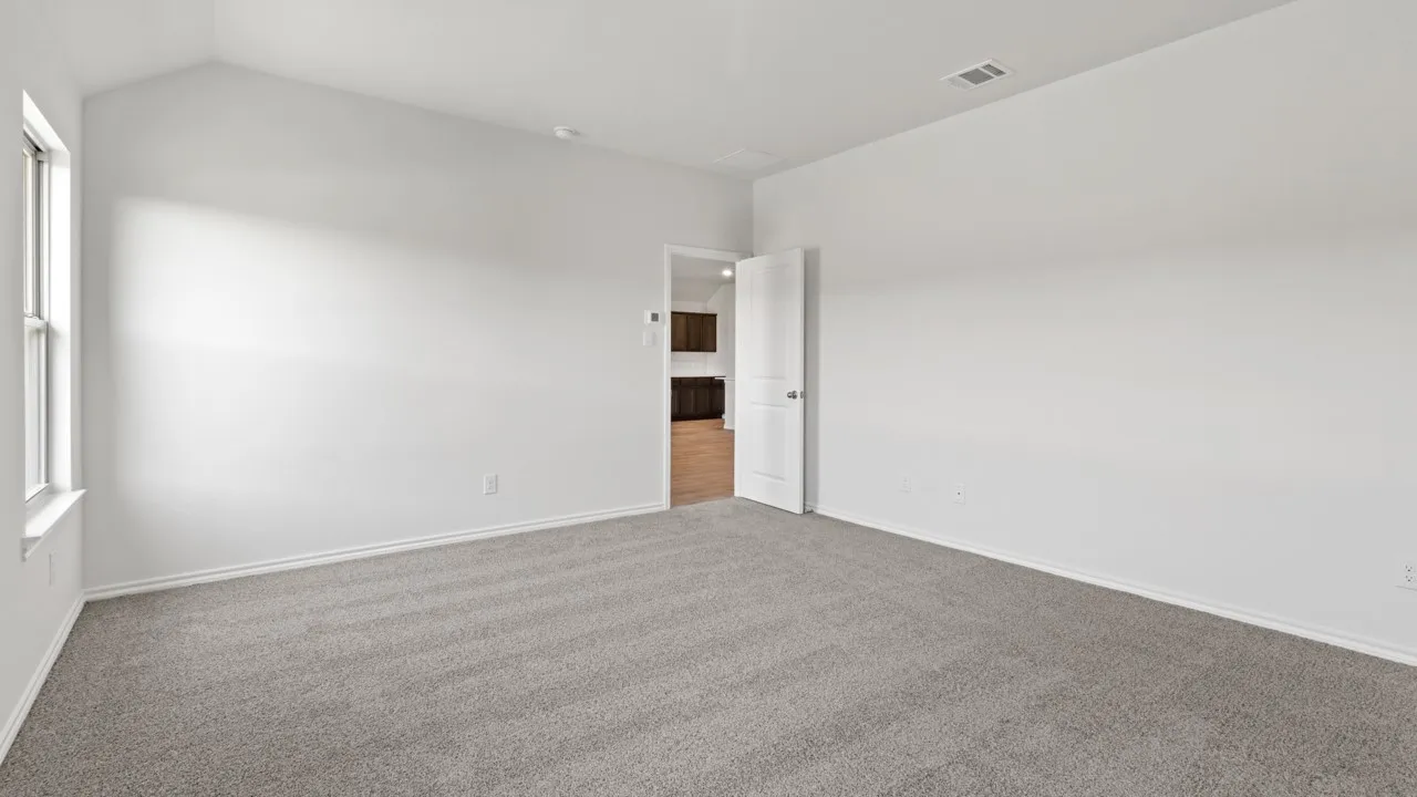 Spacious room featuring vaulted ceilings, light gray carpeting, and white baseboards