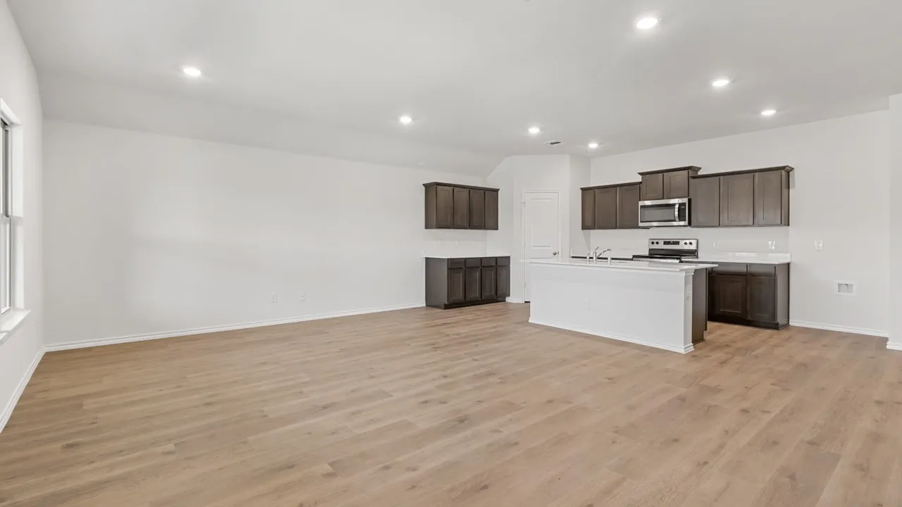 Open-concept living space featuring wood-finish flooring, recessed lighting, and a window for natural light