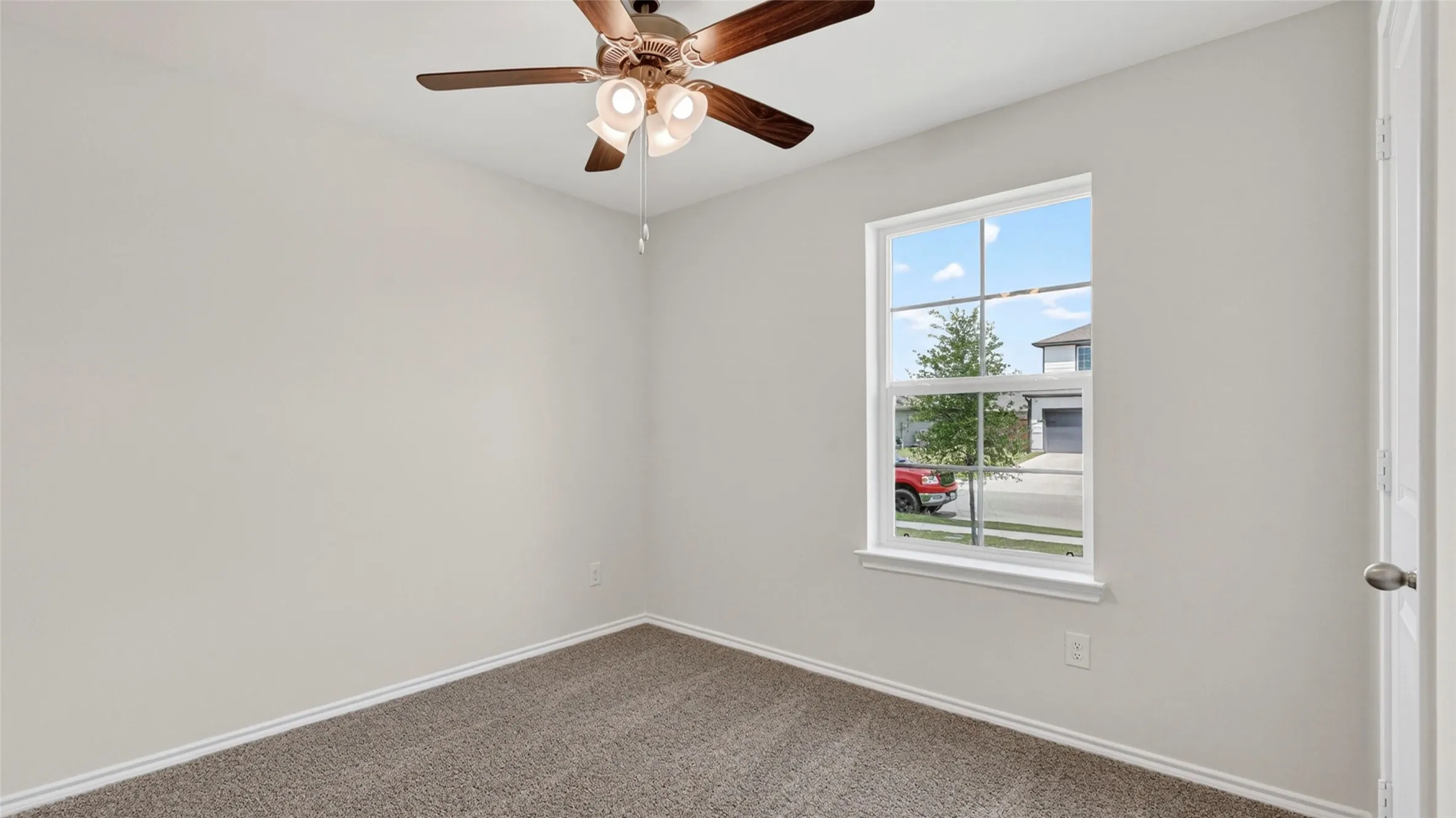 Neutral wall color complemented by a ceiling fan with integrated lighting