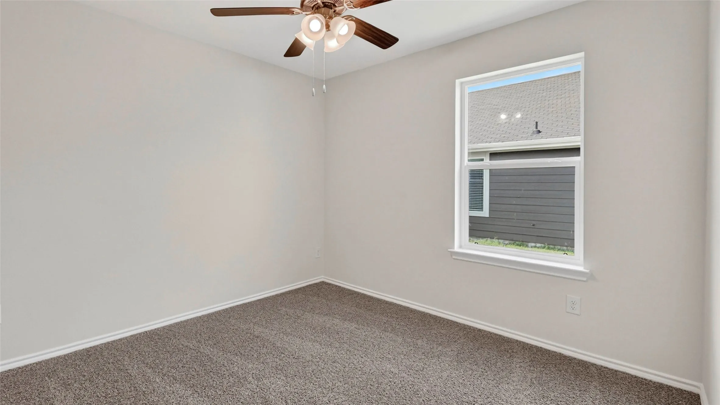 Carpeted room featuring a ceiling fan with light fixture, a single-pane window with white trim, and light-colored walls