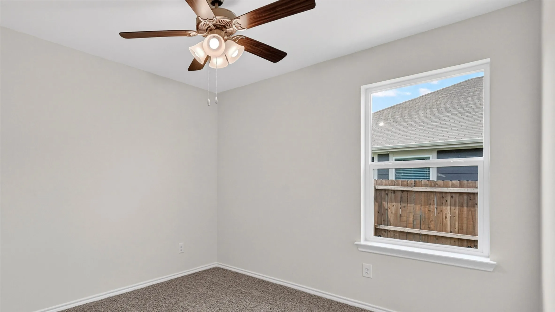 Light-colored walls with a single window featuring a white frame
