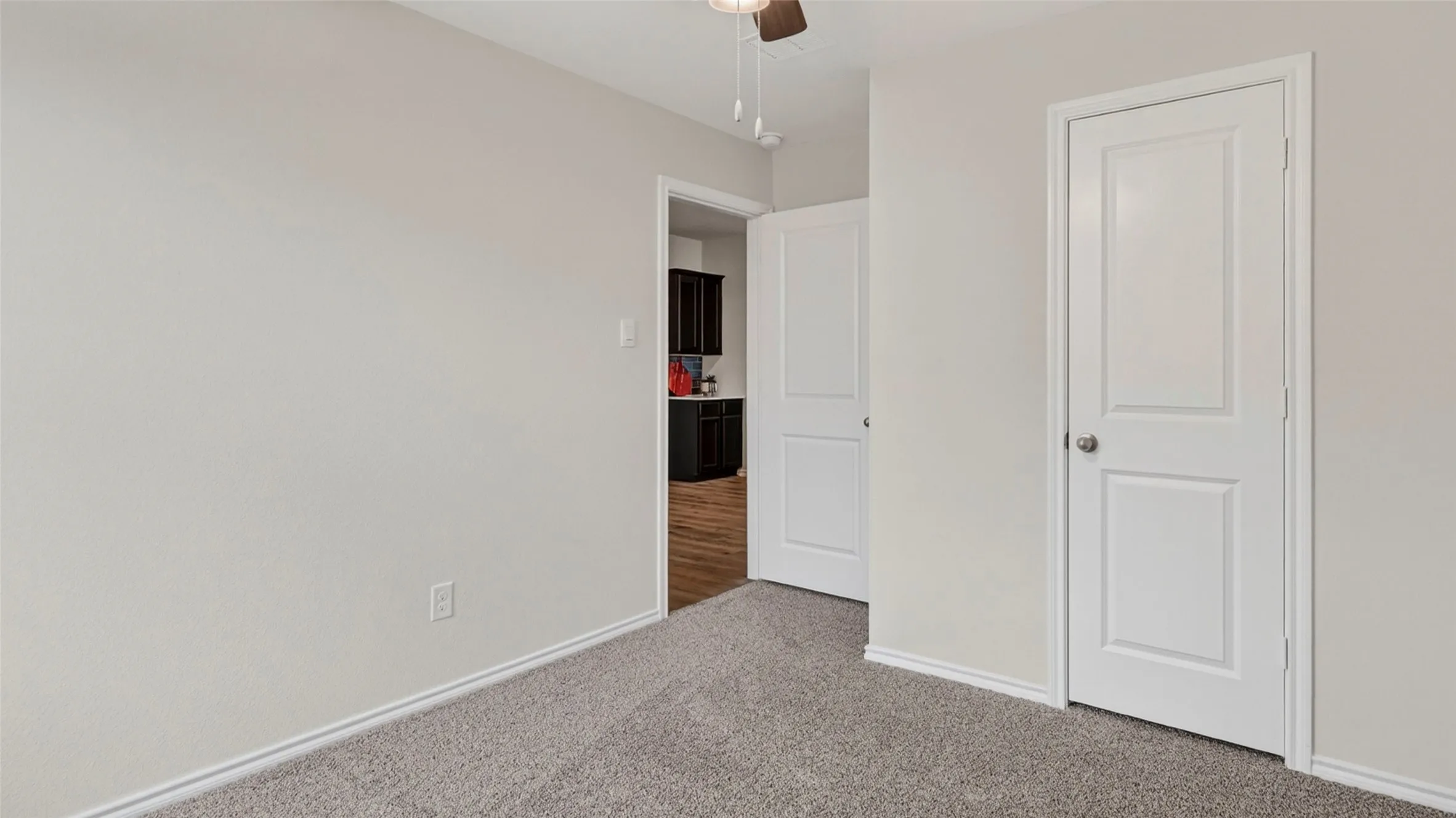 Neutral-toned walls and grey carpet flooring