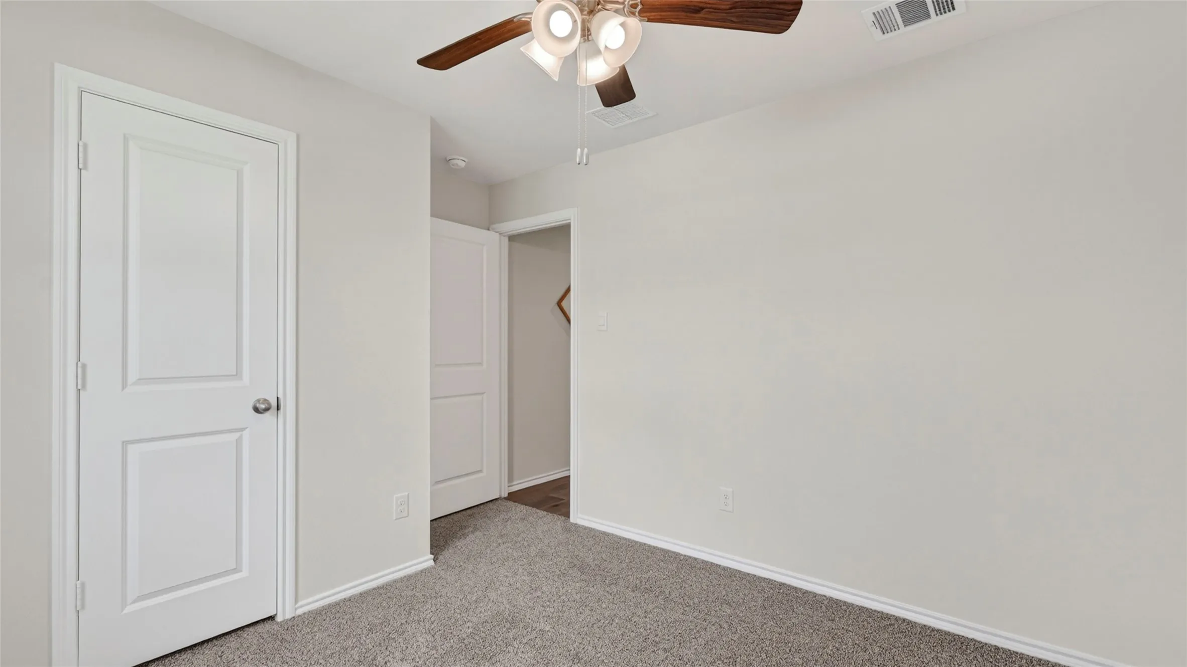 Interior room with light gray carpet, white baseboards, and light gray walls