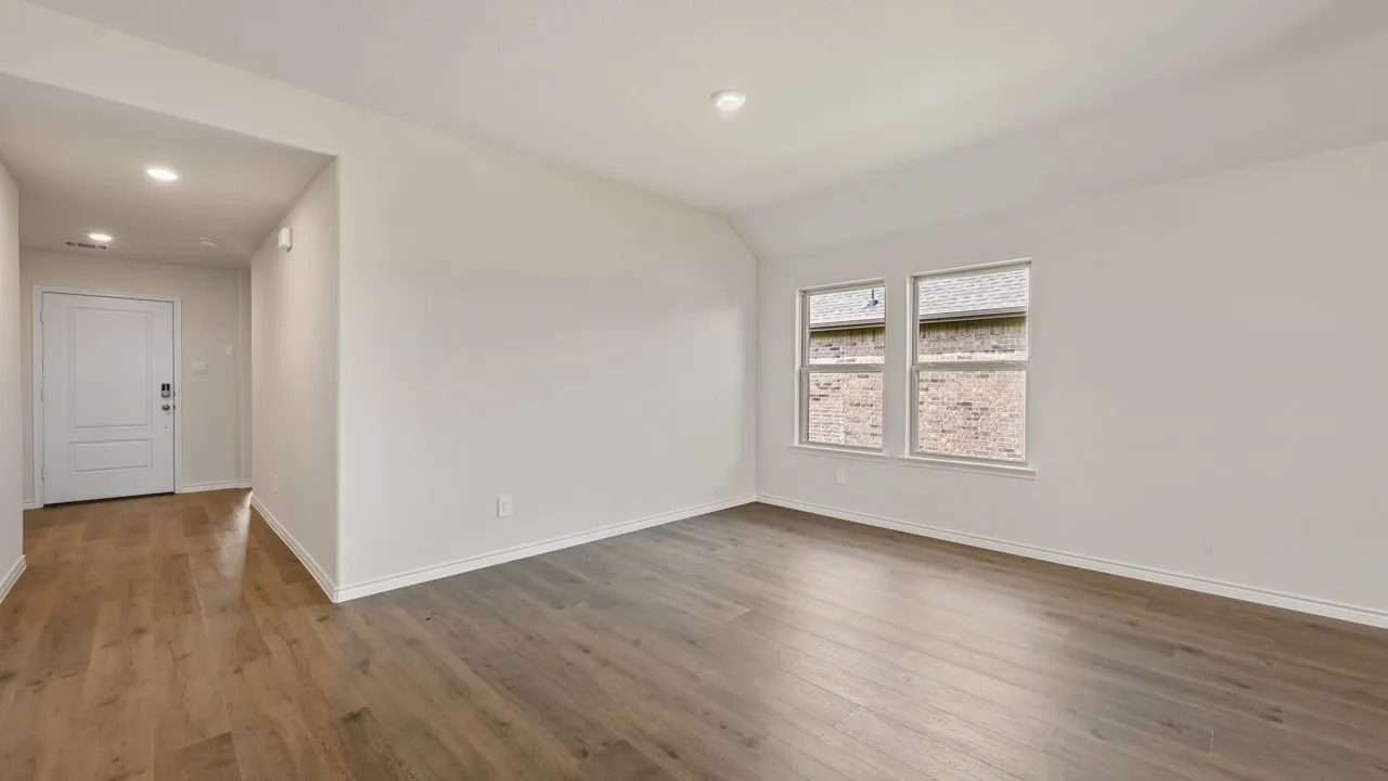 Bright interior space featuring wood-finish flooring, white walls, recessed lighting, and two windows