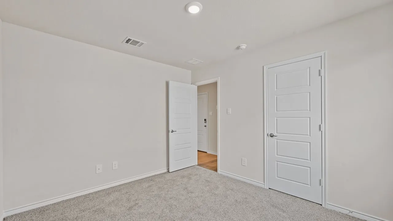 Carpeted interior space featuring light-colored walls and white trim
