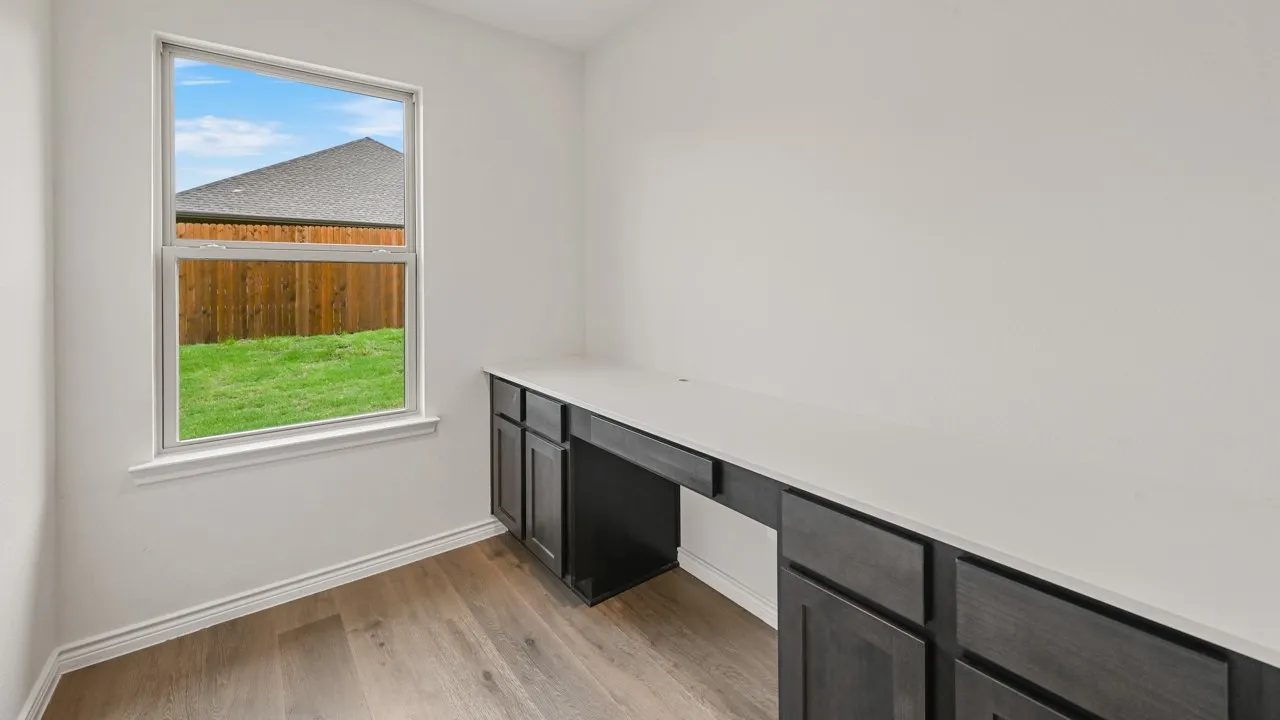 Built-in desk featuring a light-toned countertop and dark wood-finish cabinetry