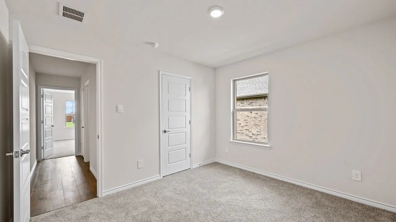 Carpeted room featuring a single window, recessed lighting, and a white paneled door