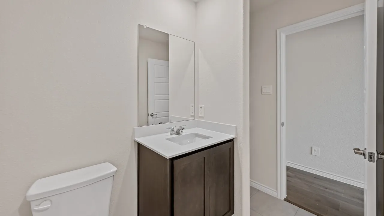 Bathroom vanity with a white countertop and dark wood cabinetry