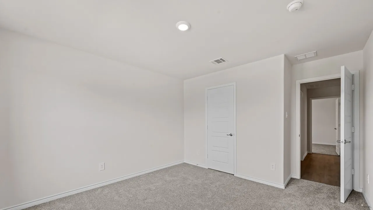 Neutral wall finishes with recessed lighting and gray carpeting