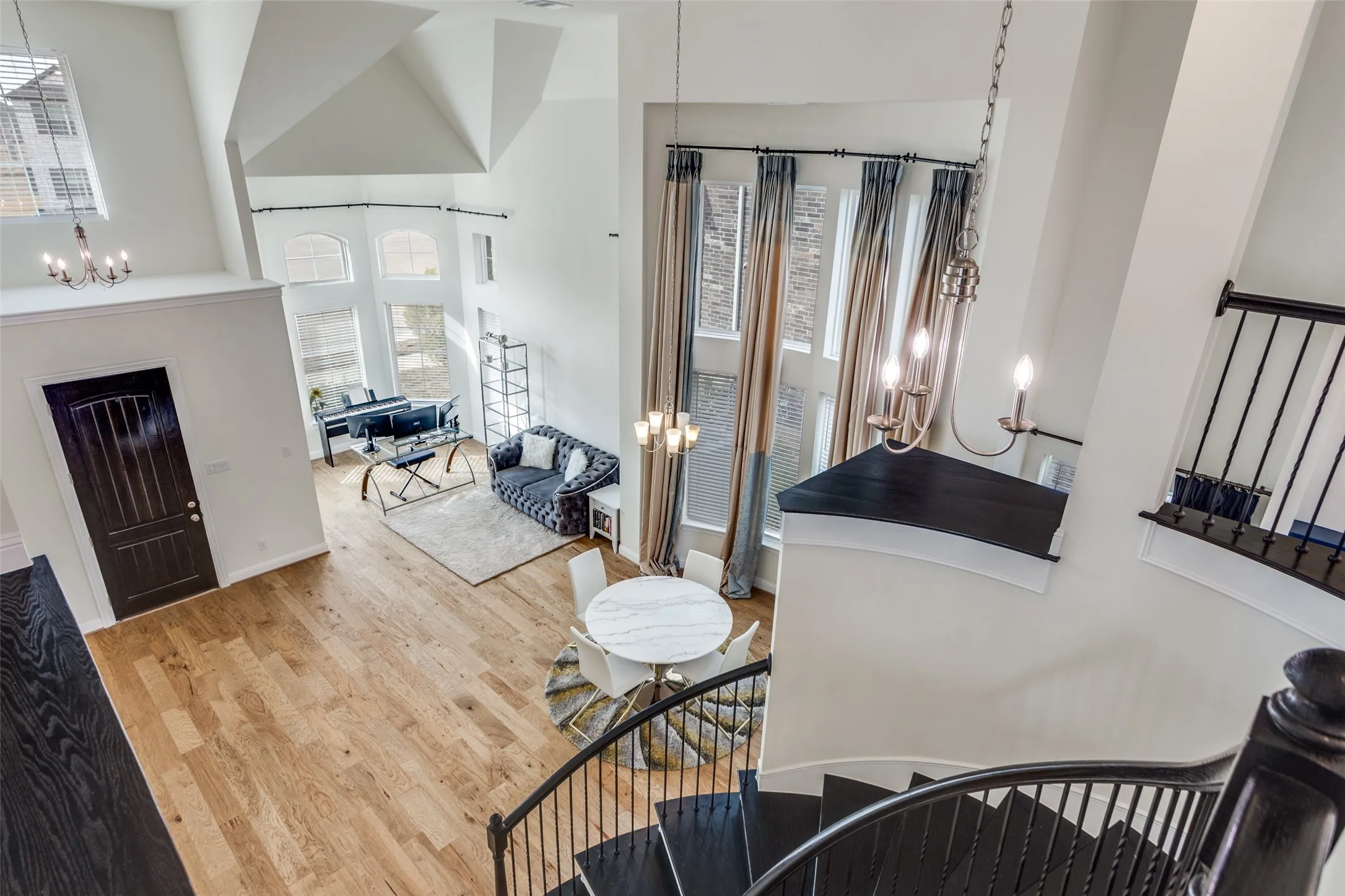 Entryway with suspended lighting, light wood-style floors, and a high ceiling