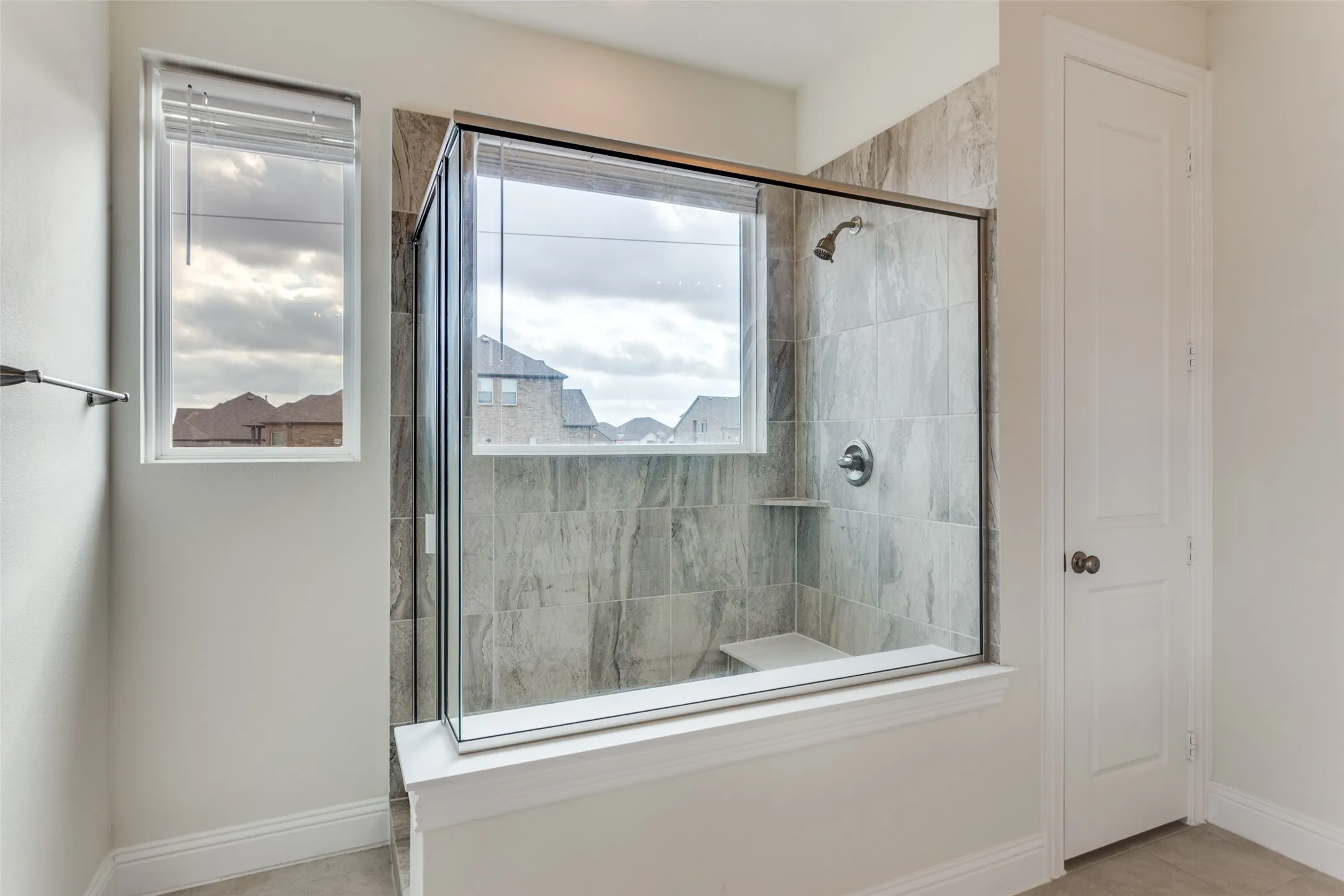 Bathroom with a stall shower and baseboards