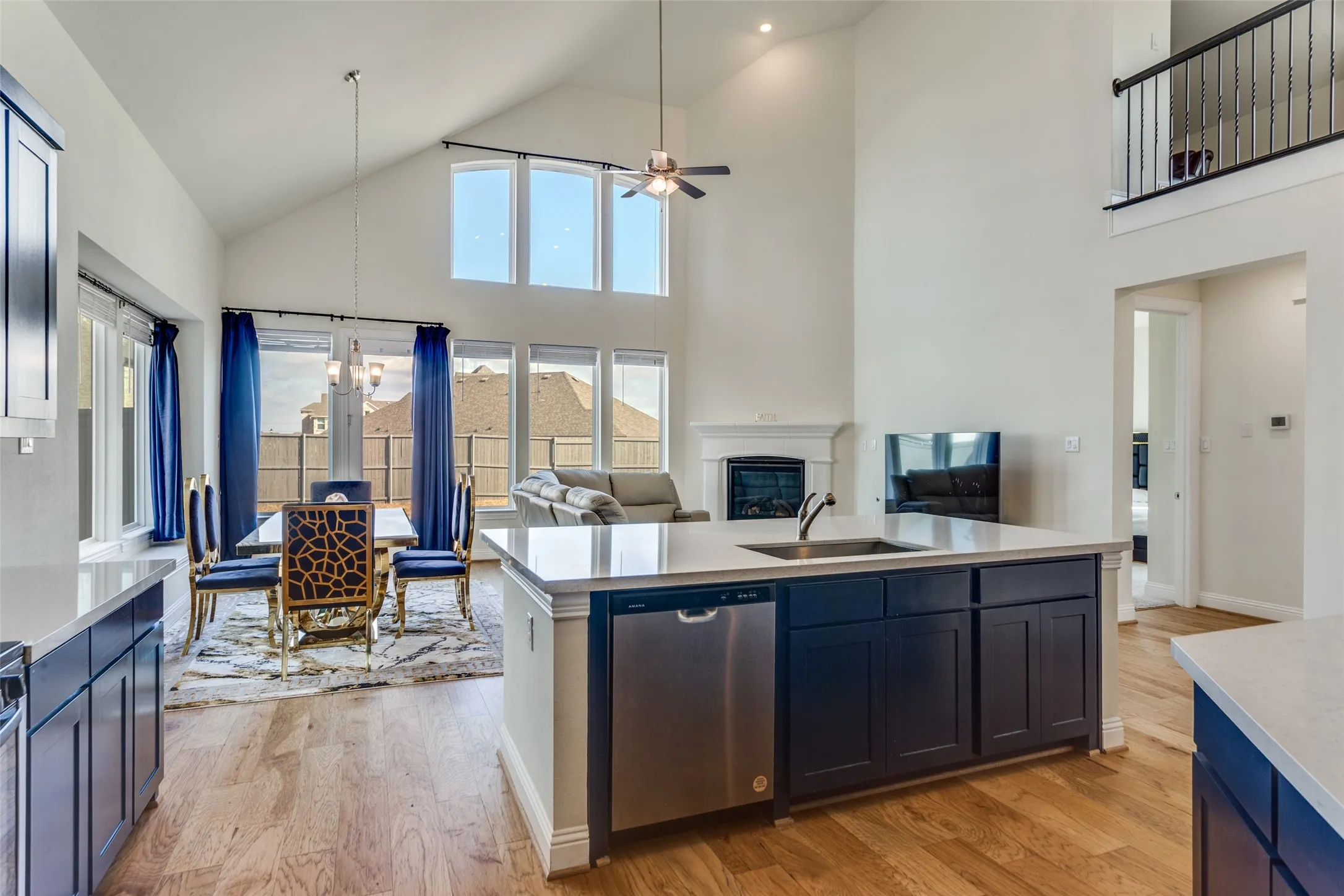 Kitchen with open floor plan, light wood finished floors, a chandelier, a ceiling fan, and vaulted ceiling