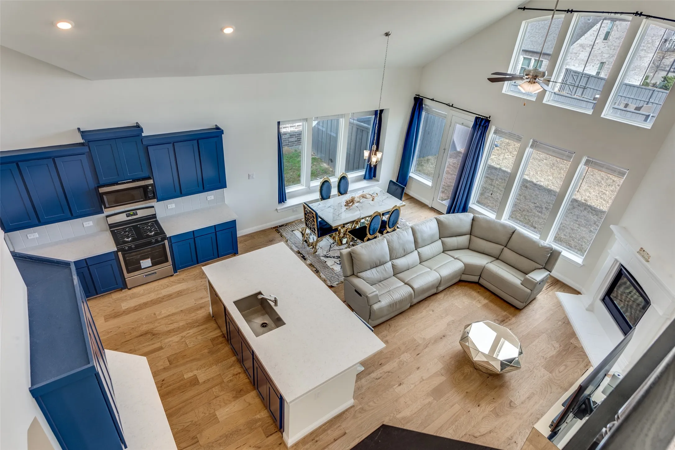 Living area with ceiling fan, light wood-style floors, and lofted ceiling