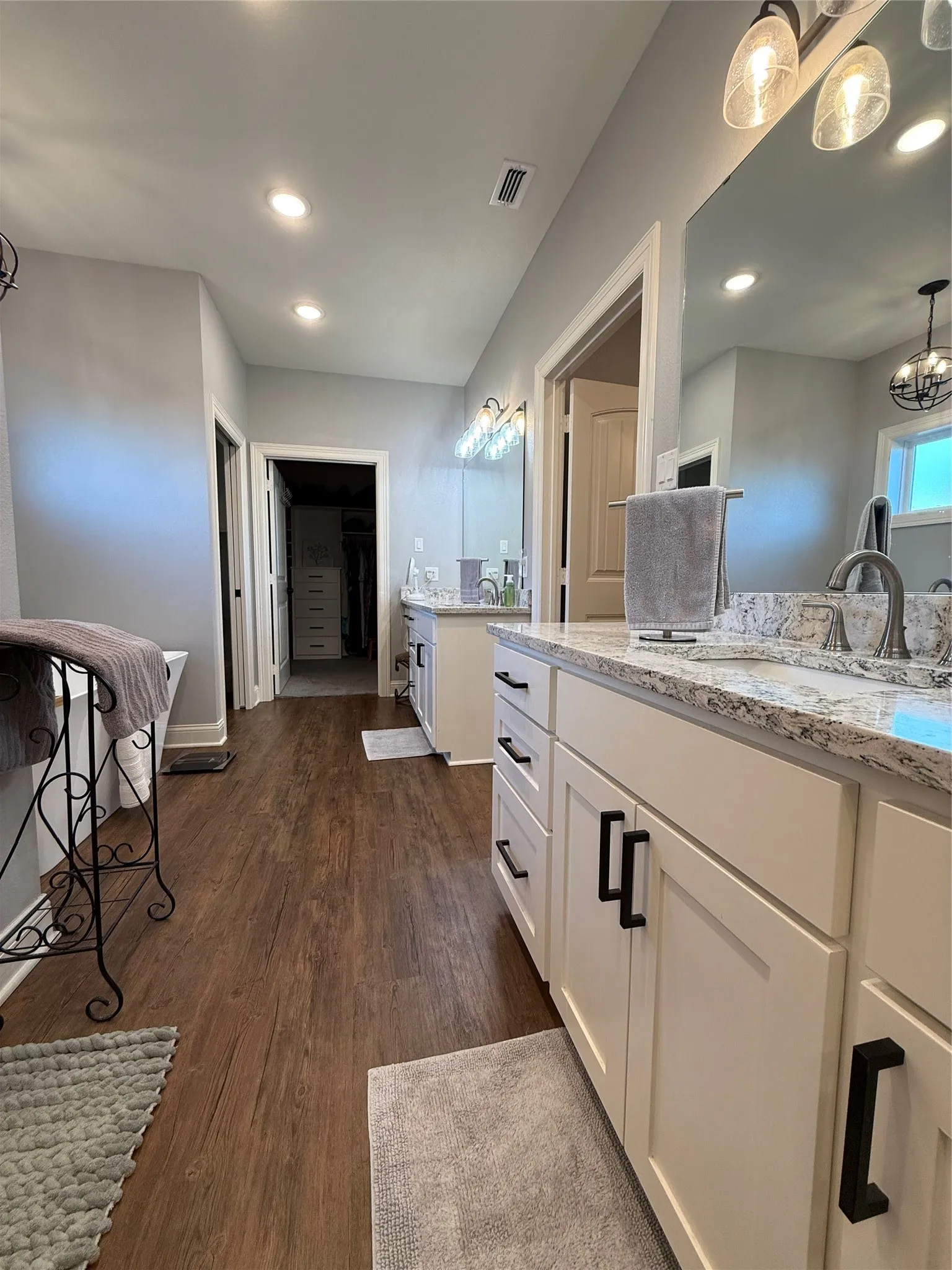 Full bathroom with two vanities, wood finished floors, recessed lighting, and baseboards