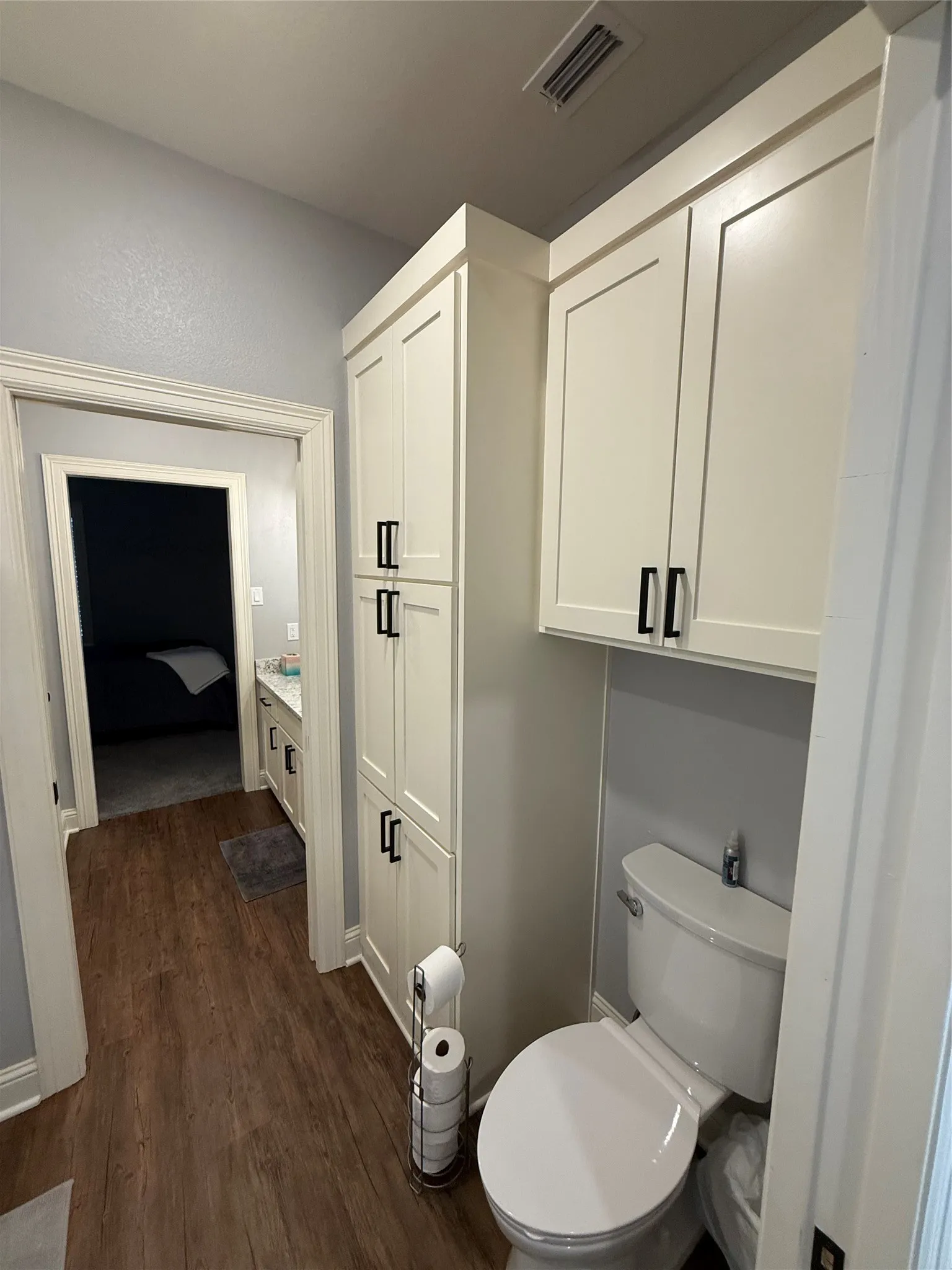 Bathroom with wood finished floors, toilet, and vanity